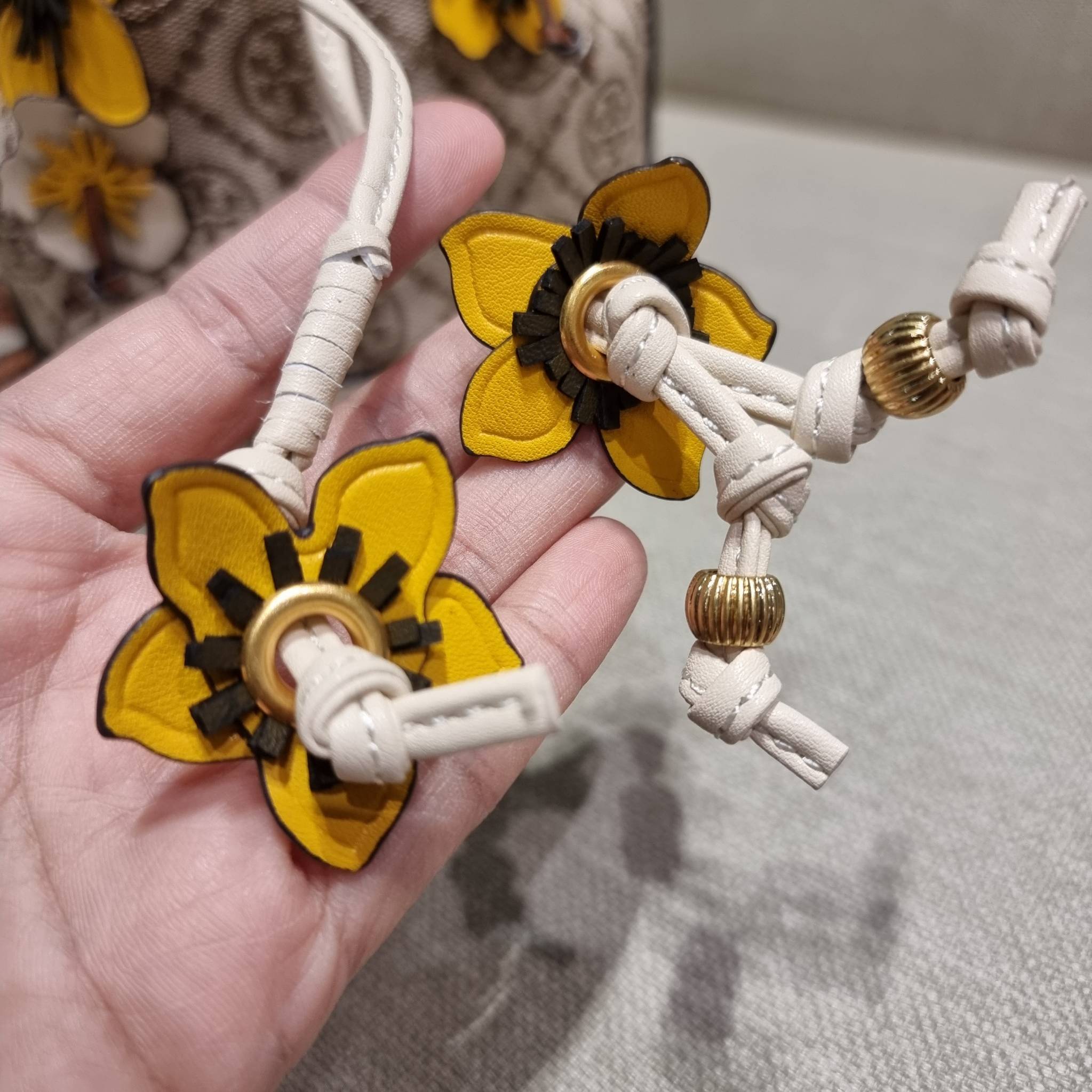 TORY BURCH MINI T MONOGRAM FLORAL BUCKET BAG คอลเลคชั่นใหม่ พร้อมเสิร์ฟความสวยให้ถึงบ้าน!! กระเป๋าบัคเก็ตทรงยอดนิยม ไซส์มินิ ดีไซน์ใหม่ล่าสุด สไตล์งานคราฟ มีลูกเล่นประดับดอกไม้กับตัวกระเป๋า และตัวรูดสาย วัสดุผ้า jacquard ตัดสลับหนังแท้ หูจับและขอบกระเป๋าต