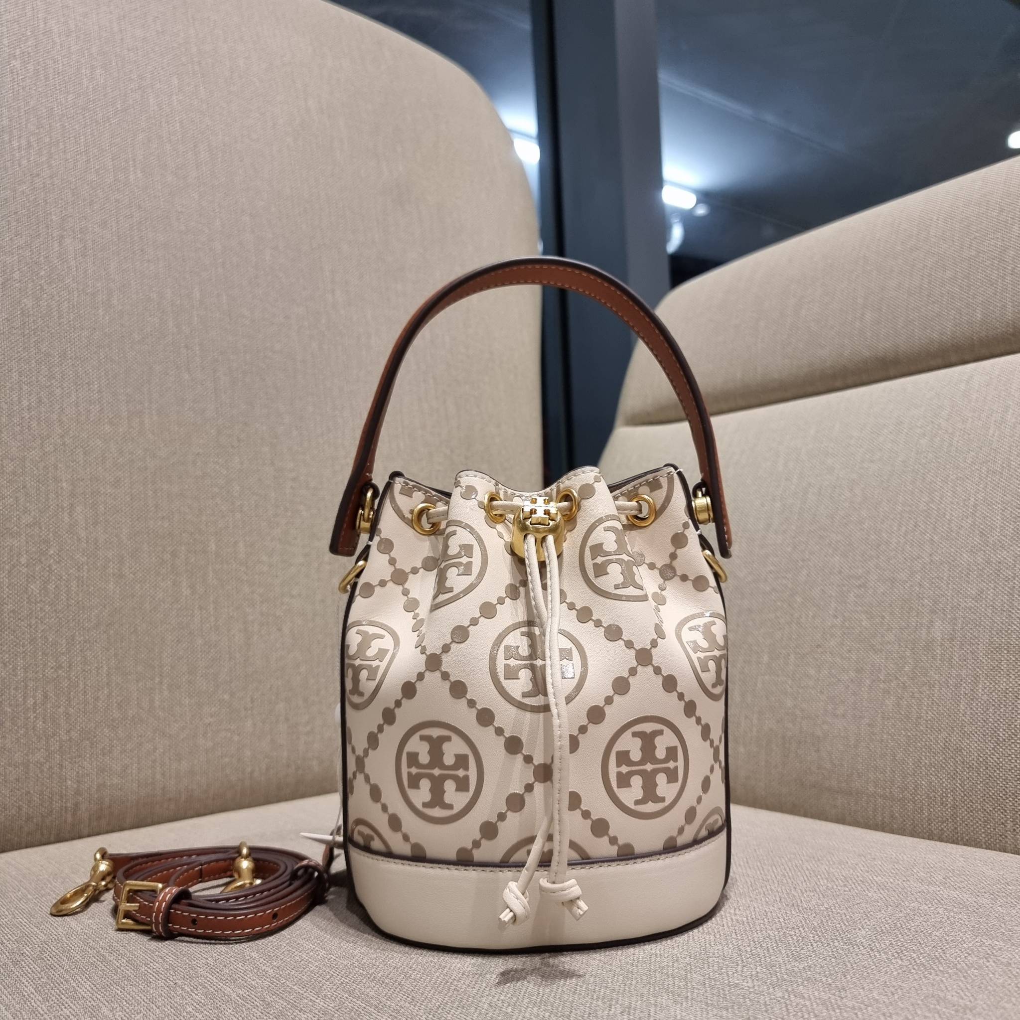 TORY BURCH T MONOGRAM EMBOSSED MINI BUCKET BAG คอลเลคชั่นใหม่ กับกระเป๋าบัคเก็ตทรงยอดนิยม ในไซส์มินิ ดีไซน์ใหม่ล่าสุด สวยลูกคุณหนู หรูหรา!! ด้วยดีเทลผิวลายนูนลวดลายเอกลักษณ์ วัสดุหนังแท้ ปากกระเป๋ารูดเปิด-ปิดได้ มีหูจับในตัว สะดวกใช้ไปอีก และมีสายสะพายข้า