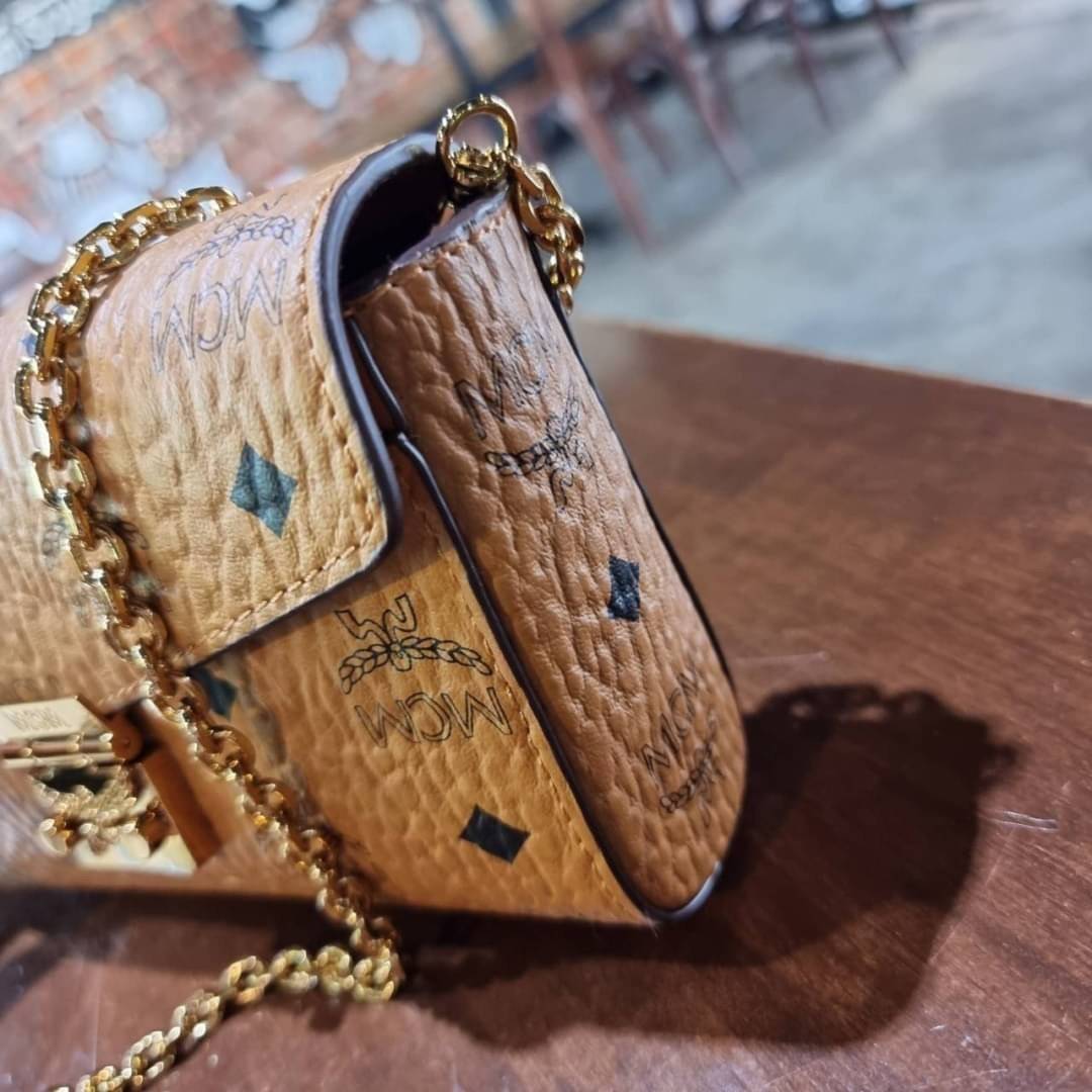 M.C.M SMALL MILLIE FLAP CROSSBODY IN VISETOS ไซส์ใหม่พกพาสะดวก!! กระเป๋าสะพายกึ่งคลัทช์ รอบนี้มาไซส์สวย สามารถใช้แทนกระเป๋าสตางค์ได้เลย ใส่โทรศัพท์มือถือได้ทุกรุ่น ใส่ของสำคัญสบายๆ มาพร้อมสายสะพายโซ่สีทองหรูหรา รูปทรงดีไซน์ร่วมสมัย ใช้งานง่ายด้วยตัวล็อค ว