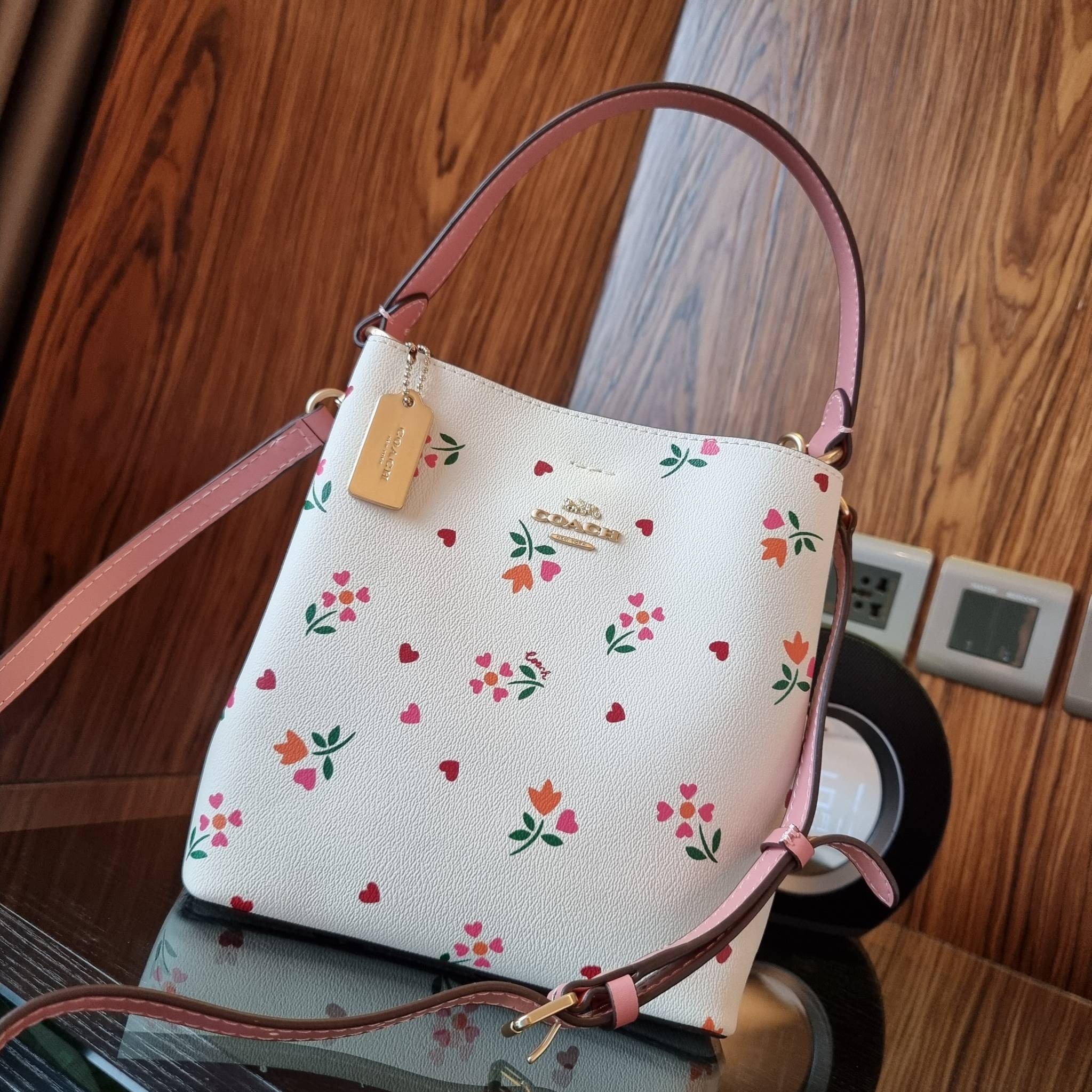 COACH C7976 SMALL TOWN BUCKET BAG WITH HEART PETAL PRINT 💕💜💕💝 คอลเลคชั่นใหม่ล่าสุด ที่พร้อมให้สาวๆได้สวยในเทศกาลแห่งความรัก กระเป๋าทรงบัคเก็ตไซส์เล็ก ดีไซน์ลวดลายสุดคิ้วท์ ช่อดอกไม้หัวใจ เห็นแล้วต้องปิ๊ง!! วัสดุหนัง pepble 