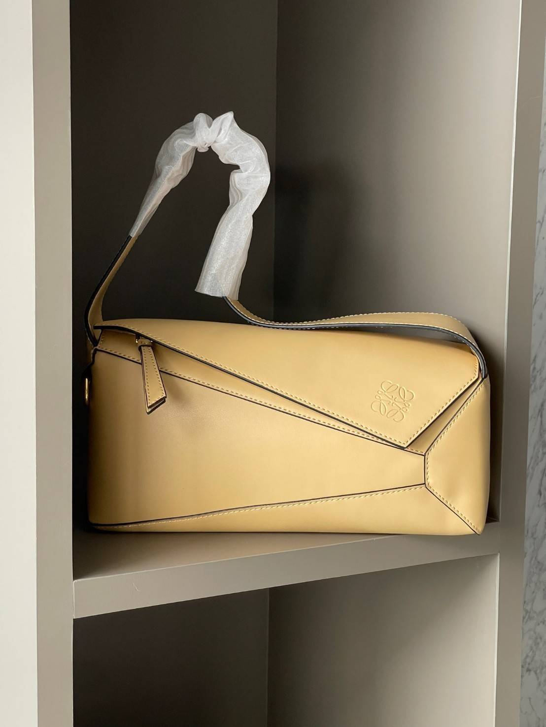 Loewe Puzzle Hobo bag กระเป๋ารุ่น Puzzle มีความพิเศษในหลายด้าน ไม่ว่าจะเป็นรูปทรงที่แปลกใหม่ มินิมอลด้วยโลโก้อนาแกรมแบบประทับ ดูหรู เป็นกระเป๋า Unisex ที่ไม่ว่าคุณจะเป็นผู้หญิงหรือผู้ชายก็ใช้งานได้ ลายกระเป๋าได้มาจากการนำหนังมาเย็บต่อกันทั้งหมด ถึงแม้ว่าข