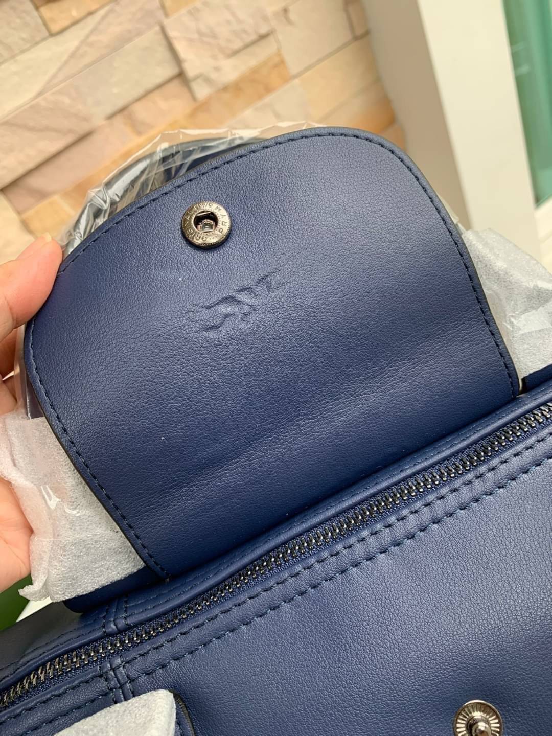 Longchamp LE PLIAGE CUIR TOP HANDLE BAG S เรียกว่าเป็นกระเป๋าอีกหนึ่งรุ่นที่ไม่ว่ายังไงก็ฮอตฮิตและติดเทรนด์ตลอดไม่เคยเปลี่ยนกับ ทรง Le Pliage Cuir หนึ่งในตระกูลกระเป๋าสุดไอคอนิกจากแบรนด์ เมื่อรุ่น Le Pliage Cuir ในรูปแบบของหนังแกะ Metis ได้ถือกำเนิดขึ้นใน