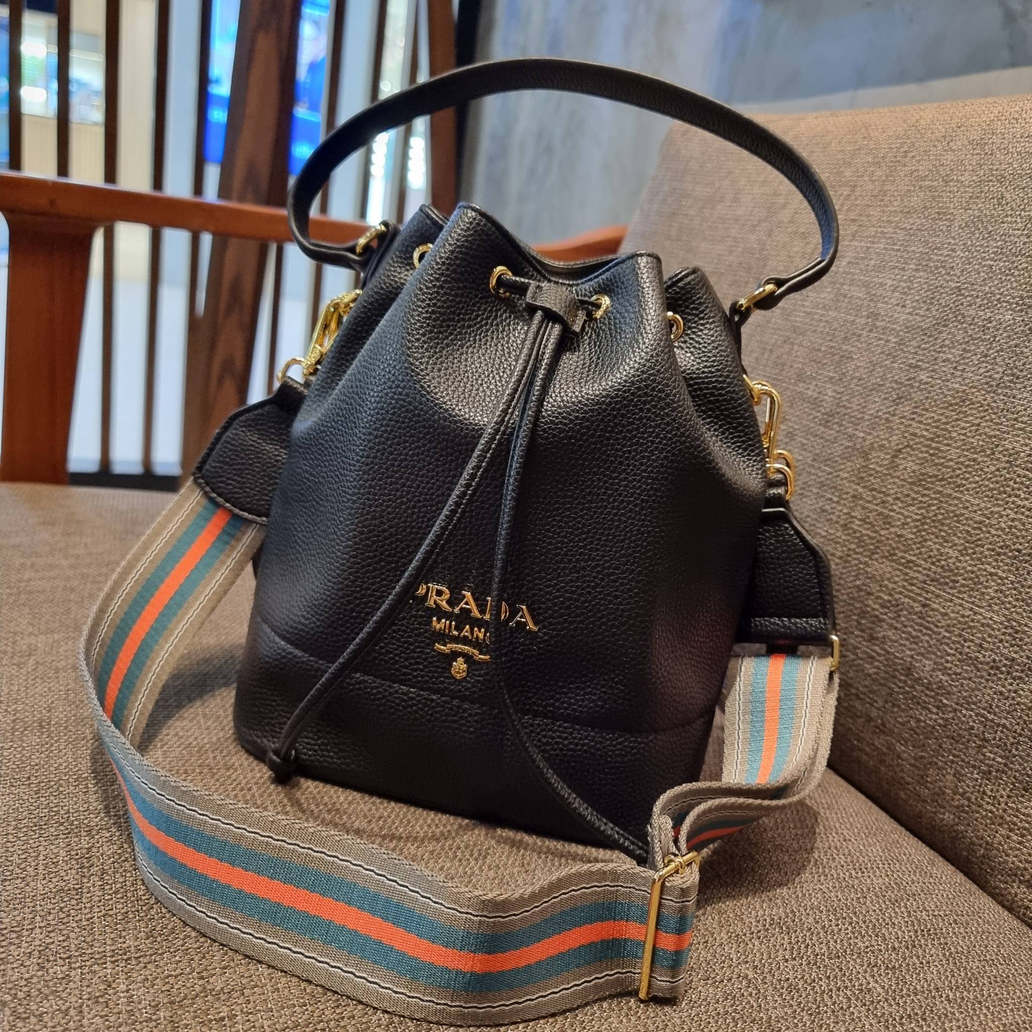 Prada leather bucket bag กระเป๋าสะพายทรงขนมจีบ ดีไซน์เรียบ แต่หรู น่าใช้มากๆ หนังสวยมาก วัสดุหนัง pepble สัมผัสนิ่มมือ ตกแต่งโลโก้สีทองตัดหนังดำ คือเลิศ!! ปากกระเป๋ารูดเปิดปิดได้ สะดวกใช้งาน ภายในโล่งกว้าง จุของได้เยอะ ไม่ธรรมดาเลย พิเศษ!! นอกจากสายคล้องใ
