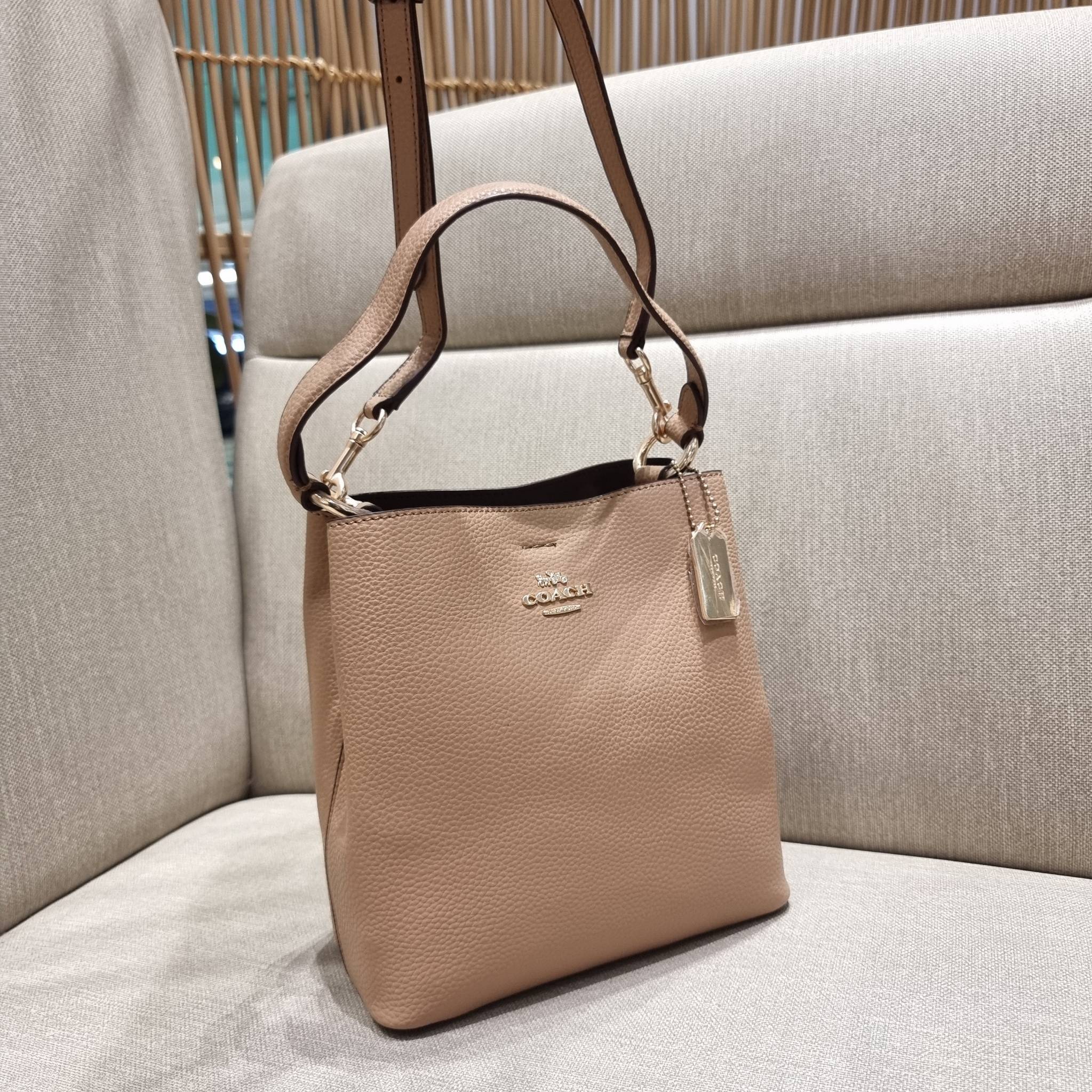COACH 1011 SMALL TOWN BUCKET BAG รุ่นยอดนิยมใบเล็ก กระเป๋าทรงบัคเก็ต สีคลาสสิคเรียบหรู ตัดกับโลโก้สีทองดูโดดเด่น วัสดุหนัง pepble สวยคมทุกมุมจริงๆ!! เปิด-ปิดด้วยกระดุมแม่เหล็กทั้ง 2 ฝั่ง ภายในเป็นช่องโล่ง มาพร้อมสายสะพายปรับได้ตามตัว ขนาดใบนี้กำลังสวย สะพ