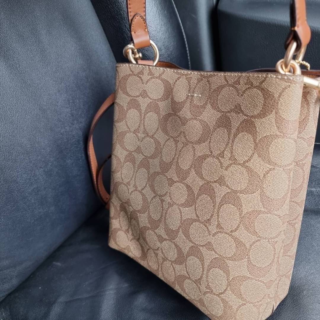 COACH 2312 SMALL TOWN BUCKET BAG IN SIGNATURE CANVAS รุ่นยอดนิยมใบเล็กมาครบสีแล้วจ้า กระเป๋าทรงบัคเก็ต สีผู้ดี๊ผู้ดี ตัวกระเป๋าดีไซน์คลาสสิคลายซี ดูโดดเด่น วัสดุหนังแคนวาสเคลือบลาย สวยคมทุกมุมจริงๆ!! เปิด-ปิดด้วยกระดุมแม่เหล็กทั้ง 2 ฝั่ง ภายในเป็นช่องโล่ง
