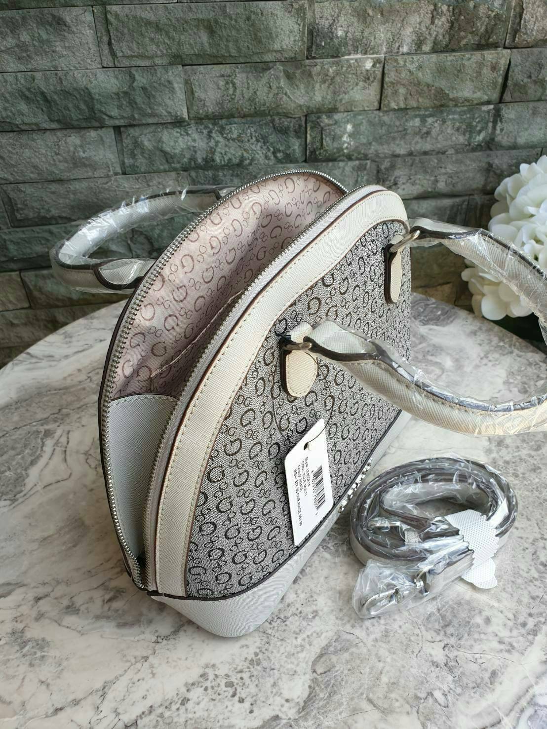 Guess Group Agata Dome Bag กระเป๋ารุ่นใหม่ล่าสุด!!! อวดไอเทมแสนเก๋กับกระเป๋าทรงโดม ทรงยอดนิยม สวยคลาสสิค สุดน่ารัก พิมพ์ลายรอบใบ วัสดุ Saffiano PU คุณภาพดี นิ่ม น้ำหนักเบา ด้านหน้าประดับด้วยโลโก้แบรนด์สวยโดดเด่น เปิดปิดด้วยซิปสะดวกใช้ ด้านในโล่งกว้างมีช่อ