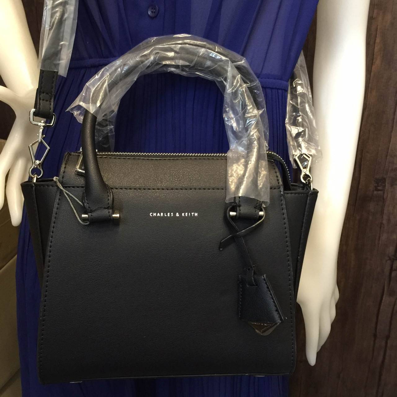 CHARLES & KEITH MINI CITY BAG กระเป๋าถือหรือสะพาย ขนาดกะทัดรัด กำลังดี หนังpu เรียบ อยู่ทรงแข็ง เปิด-ปิดด้วยซิป ด้านหน้าห้อยประดับอะไหล่ปั๊มโลโก้ ดูเรียบหรู ภายในมีช่องซิปเล็ก 1 ช่อง มาพร้อมสายสะพายยาวปรับได้ ฐานมีหมุดรองฐานกันรอยสี่มุม สะพายสบายๆไปเที่ยว