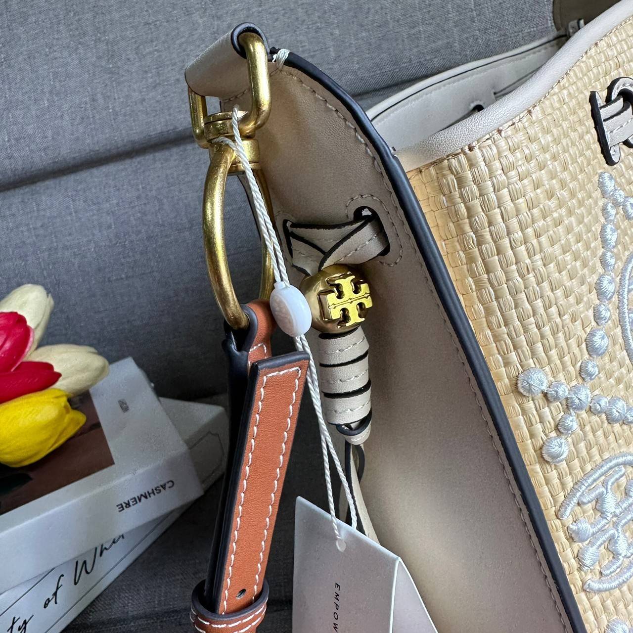 TORY BURCH T Monogram Straw Bell Bag กระเป๋าสะพายข้างรุ่นคลาสสิกที่ได้แรงบันดาลใจจากการควิลท์แบบดั้งเดิมของเพนซิลเวเนีย คอลเลกชันบ่งบอกถึงความมีสไตล์เหนือกาลเวลา รูปทรงเรียวโดดเด่น ปักทอลายแบรนด์อย่างสวยงาม เปิด ปิดด้วยเชือกรูด ด้านในช่องโล่งกว้าง ซับในผ้