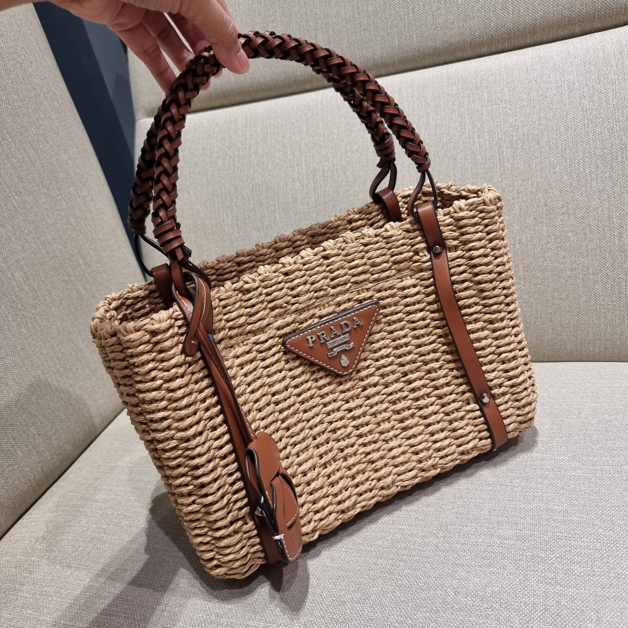 PRADA CORN HUSK AND LEATHER TOTE ธรรมชาติเป็นหนึ่ง!! กับอีกไอเท็มรักษ์โลก ด้วยดีไซน์ล้ำทันสมัย ผสานกับวัสดุจากธรรมชาติ ออกมาเป็นลายสานที่สวยหรู ไม่กระด้าง กระเป๋าทรงโท้ท ขนาดกำลังสวย มาพร้อมหูจับในตัว มีซิปรูปเปิด-ปิดที่ปากกระเป๋า ภายในโล่งกว้าง ใส่ของได้