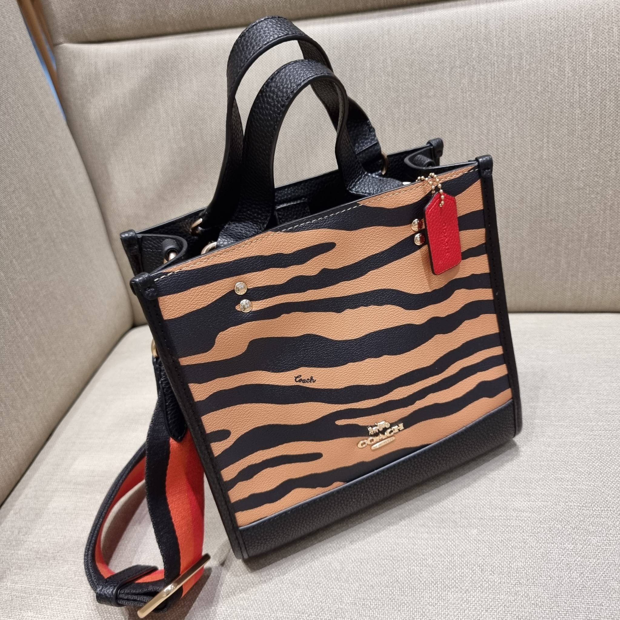 COACH C6988 DEMPSEY TOTE 22 WITH TIGER PRINT ใหม่ล่าสุดน้องเสือนำทรัพย์ 🐯🐯 คอลเลคชั่นฉลองปีเสือต้องมาจ้า กับรุ่นสวยคลาสสิค กระเป๋าทรงโท้ท ขนาดน่ารักน่าใช้มากๆ ดีไซน์พริ้นท์ลายเสือดึงดูดสายตา สวยมีสเน่ห์ที่สุด!! ฟังก์ชั่นการใช้งานสะดวก มีทั