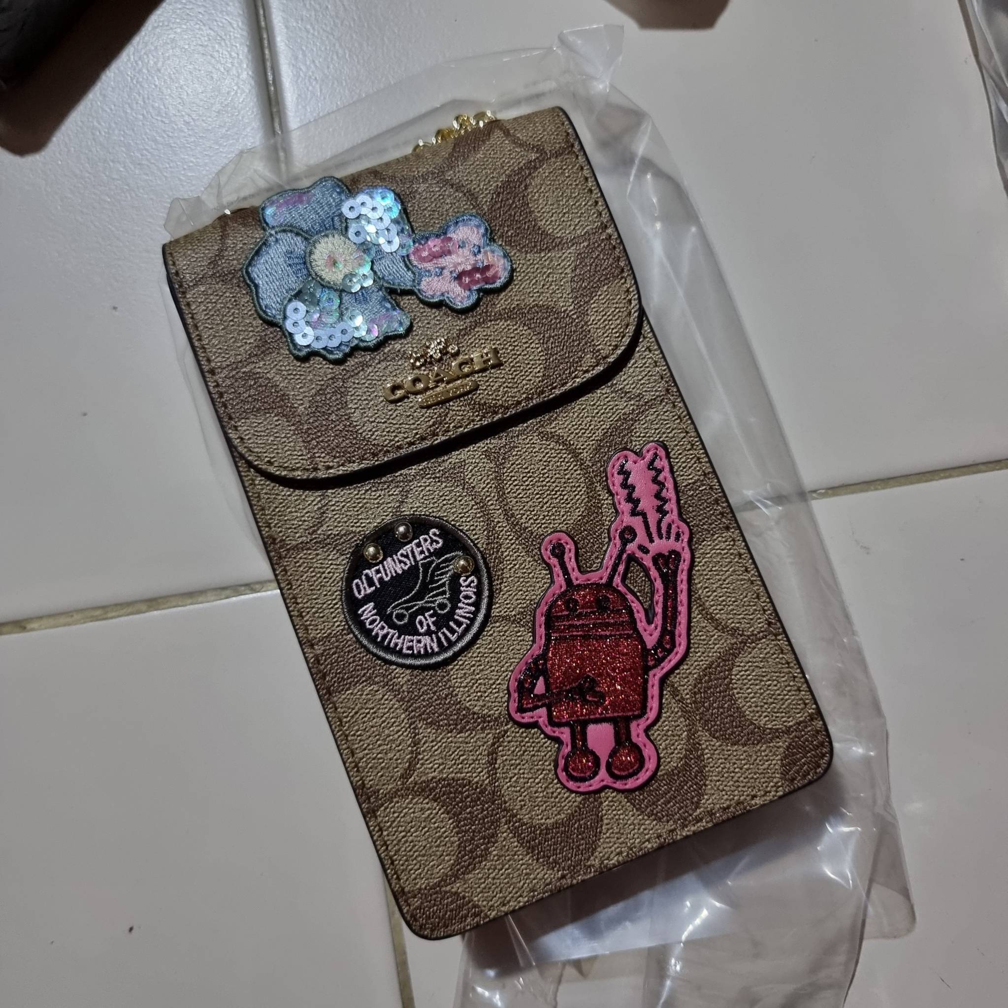 COACH NORTH/SOUTH PHONE CROSSBODY IN SIGNATURE CANVAS F55636 F39955 สุดคลาสสิคกับกระเป๋าสะพายเอนกประสงค์ Case phone ใส่โทรศัพท์มือถือได้ทุกรุ่น ดีไซน์ลายเอกลักษณ์ วัสดุหนังแคนวาสเคลือบลาย ฝาและภายในเป็นหนังสังเคราะห์เรียบ เปิด-ปิดด้วยกระดุม สายสะพายยาวประ