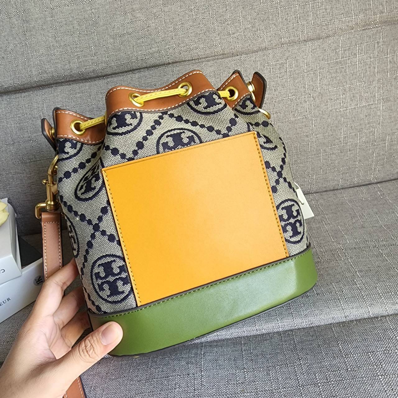 Tory Burch T Monogram Colorblock Bucket Bag กระเป๋าสะพาย ทรงบัคเกต รุ่นฮอต สไตล์ไหนเข้าได้ทุกลุค วัสดุ jacquard ตัดขอบหนังแท้ ภายในเป็นช่องโล่งกว้าง ใส่ของได้เยอะหยิบจับสะดวก มาพร้อมสายสะพายข้างหนังแท้ ถอดและปรับระดับได้สะพายชิวได้ทุกโอกาส