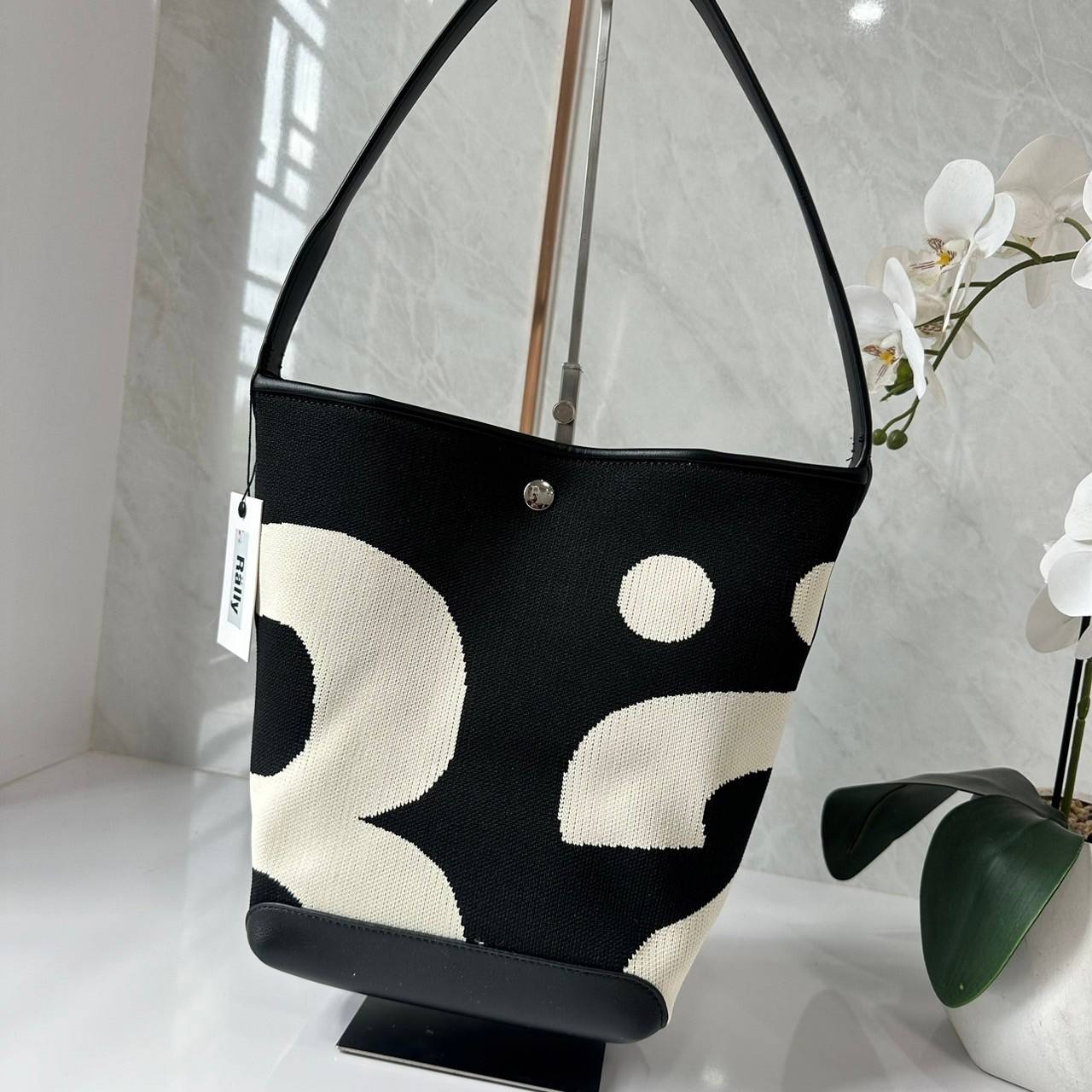 Rally movement the bag Knit Black เป็นไอเท็มที่ฮอตสุดๆแห่งปีจริงๆ กับกระเป๋าทรงบัคเก็ต น้ำหนักเบาๆ ฮอทติดลมบน จุของได้แบบหนำใจ ทอลายโลโก้ด้วยเทคนิค Sturdy Stretch Knit