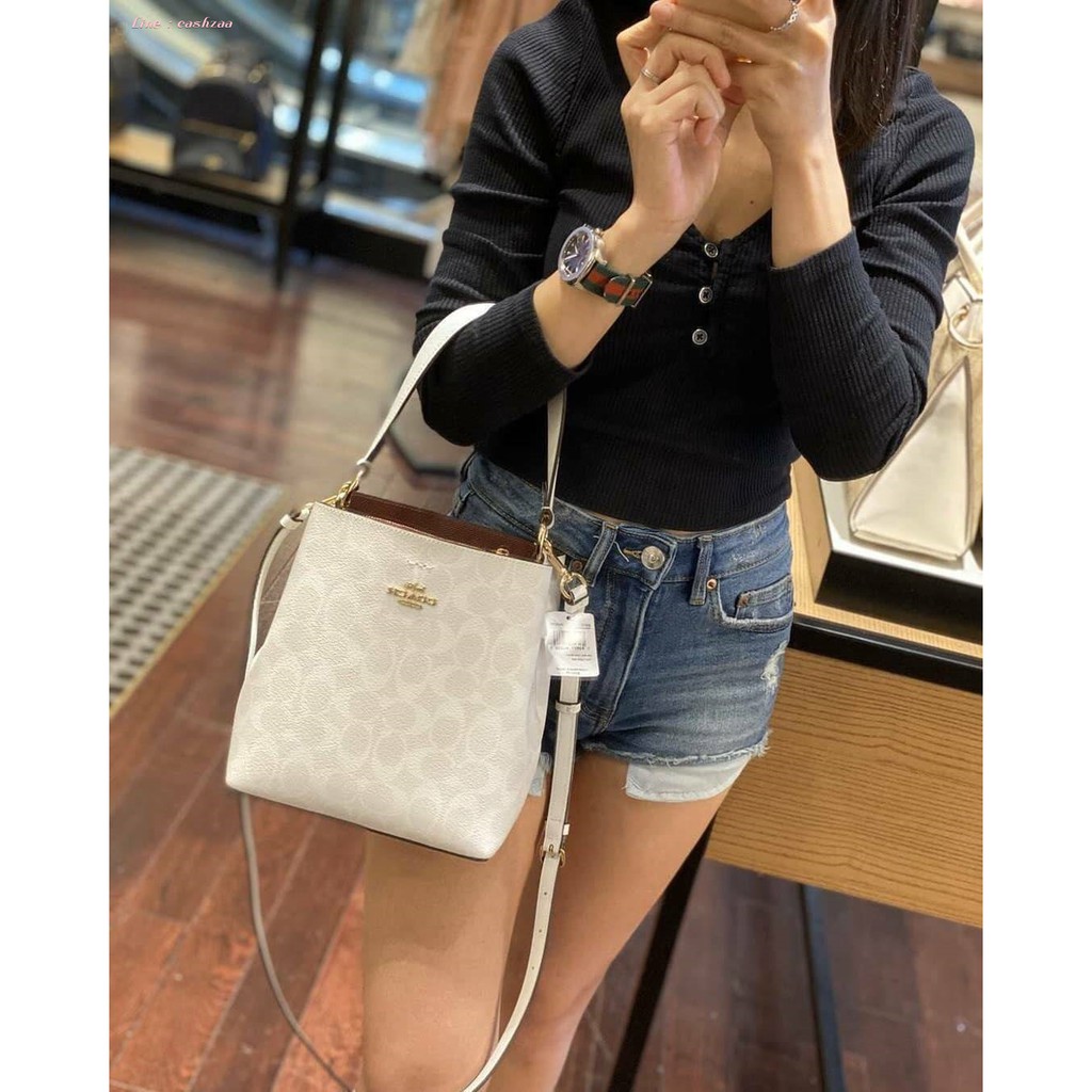 COACH 2312 SMALL TOWN BUCKET BAG IN SIGNATURE CANVAS รุ่นยอดนิยมใบเล็กมาครบสีแล้วจ้า กระเป๋าทรงบัคเก็ต สีผู้ดี๊ผู้ดี ตัวกระเป๋าดีไซน์คลาสสิคลายซี ดูโดดเด่น วัสดุหนังแคนวาสเคลือบลาย สวยคมทุกมุมจริงๆ!! เปิด-ปิดด้วยกระดุมแม่เหล็กทั้ง 2 ฝั่ง ภายในเป็นช่องโล่ง
