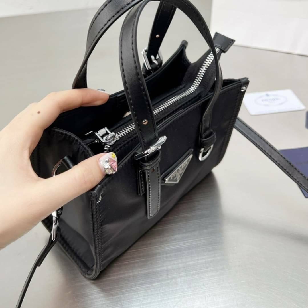 VIP 🥂 PRADA NYLON TOTE BAG 8" กระเป๋าถือหรือสะพาย วัสดุ Nylon เนื้อหนาคุณภาพดีตามแบบฉบับแบรนด์ด้านหน้าประดับโลโก้หรู จุของใช้ได้เยอะ น้ำหนักเบา งานตัวจริงสวยมากน่าใช้สุดๆค่ะ รีบจับจองด่วน ไอเท็มนี้พลาดไม่ได้จริงๆค่ะ!