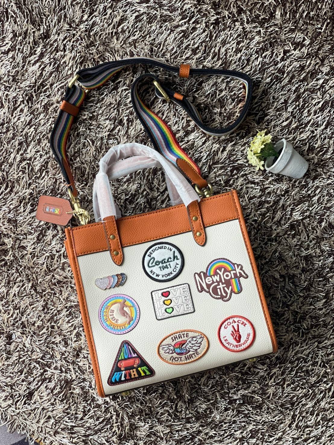COACH FIELD TOTE 22 WITH PATCHES CA138 ส่วนหนึ่งจาก Coach Pride Collection ซึ่งเป็นการเฉลิมฉลองความเท่าเทียม ความหลากหลาย และการแสดงออกถึงตัวตนที่แท้จริงภายในชุมชน LGBTQIA+ ในเดือนนี้และทุกเดือน ตั้งแต่วันธรรมดาที่วุ่นวายไปจนถึงวันหยุดสุดสัปดาห์ที่เต็มไปด