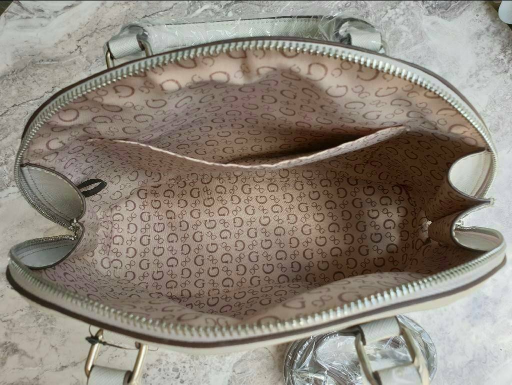 Guess Group Agata Dome Bag กระเป๋ารุ่นใหม่ล่าสุด!!! อวดไอเทมแสนเก๋กับกระเป๋าทรงโดม ทรงยอดนิยม สวยคลาสสิค สุดน่ารัก พิมพ์ลายรอบใบ วัสดุ Saffiano PU คุณภาพดี นิ่ม น้ำหนักเบา ด้านหน้าประดับด้วยโลโก้แบรนด์สวยโดดเด่น เปิดปิดด้วยซิปสะดวกใช้ ด้านในโล่งกว้างมีช่อ