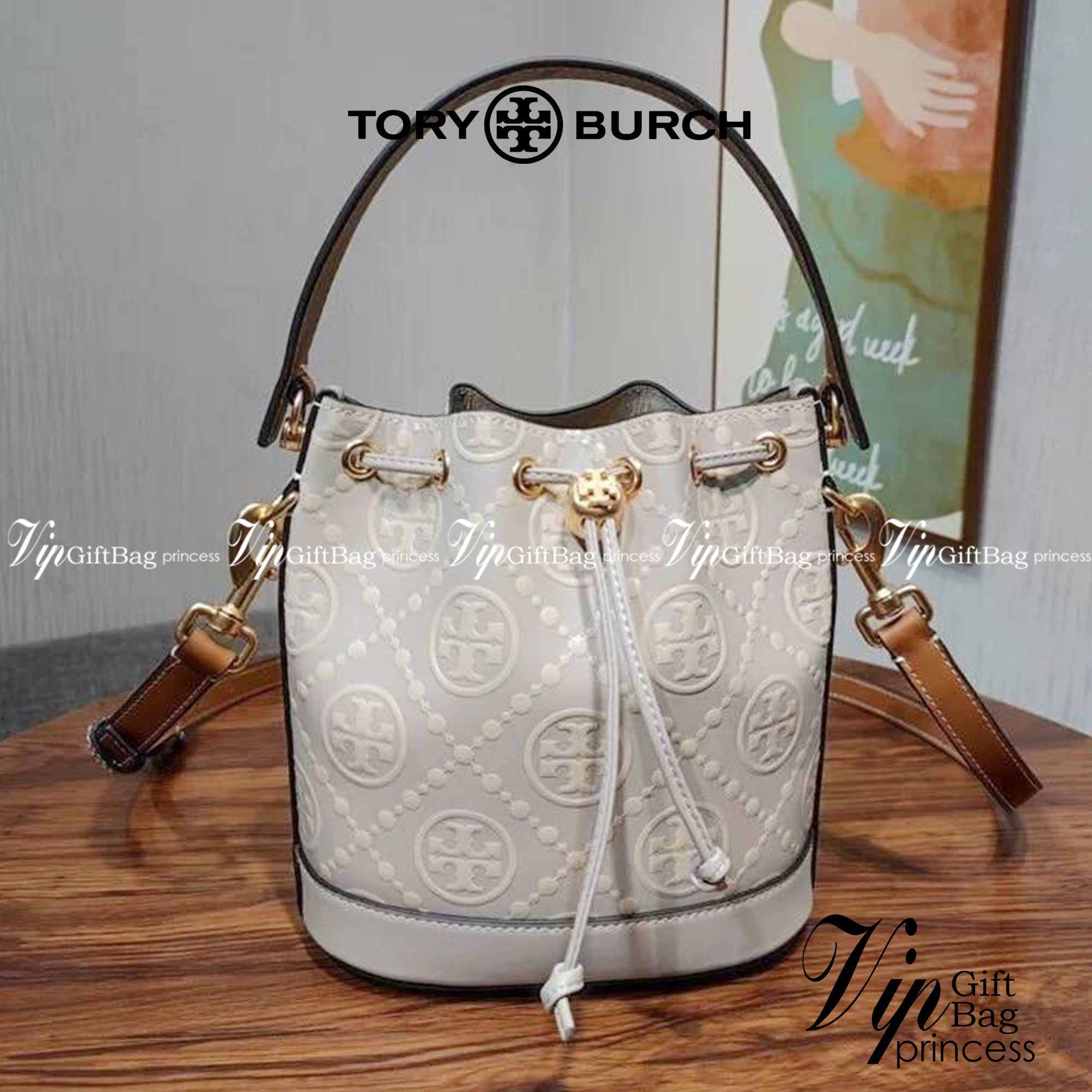 Medium : Tory Burch T Monogram Embossed Bucket Bag กระเป๋าถือหรือสะพายไหล่ ประดับด้วยลวดลายอันเป็นสัญลักษณ์ของแบรนด์ ถูกประดิษขึ้นด้วยความพิถีพิถันวัสดุหนังอย่างดี ด้านในบุด้วยหนังไมโครซูแอคเนื้อนุ่มทำความสะอาดง่าย กระเป๋าผ่าหลังด้านนอก1ช่อง ด้านใน 1ช่อง 