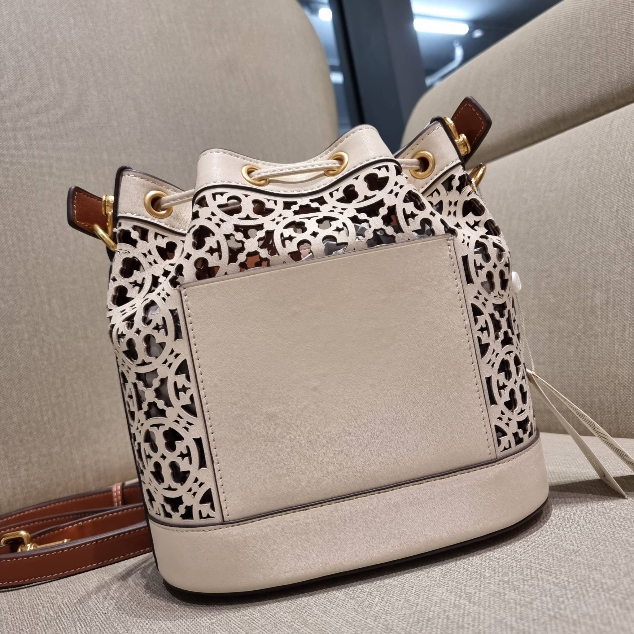 TORY BURCH T MONOGRAM LASER-CUT BUCKET BAG ใจบางที่สุดกับคอลเลคชั่นนี้ กับกระเป๋าสะพายทรงบัคเก็ต รุ่นชูโรงสุดฮิต ที่เพิ่มดีเทลความแพงด้วยการฉลุลวดลายโมโนแกรมรอบใบ ถักทอเป็นเส้นลายสานที่สวยงามมาก งานฝีมือจริงๆ วัสดุหนัง cowhide รูดเปิด-ปิดด้วยเส้นหนัง มาพร