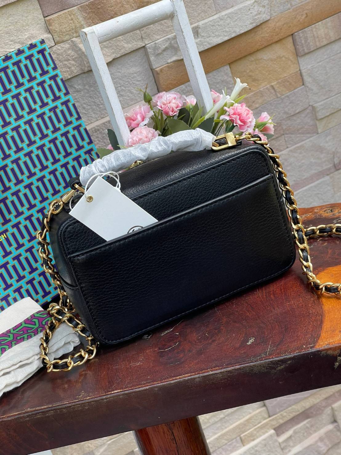 Tory burch Top Handle Case (84710) Collection ใหม่ที่เพิ่งเปิดตัวไปไม่นานจุดเด่นของรุ่นนี้คือดีไซน์ออกมาในสไตล์คลาสสิกที่มาพร้อมกับฮาร์ดแวร์ที่ทำจากวัสดุทองเหลืองและสายสะพายโซ่และหนัง ปากกระเป๋าเปิดได้กว้างแบบสองซิป รูปทรงสามารถสะพายใช้งานได้หลายโอกาส ไม่