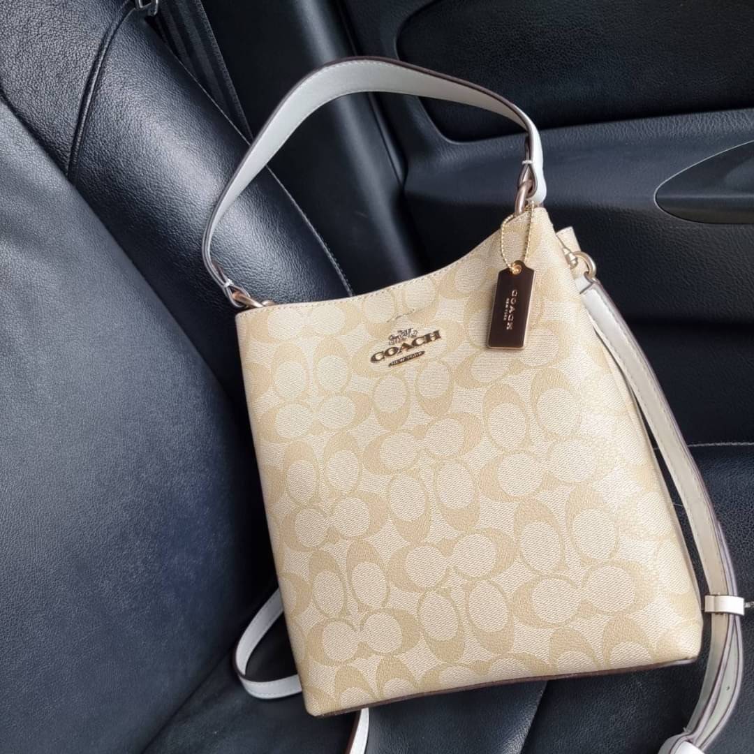 COACH 2312 SMALL TOWN BUCKET BAG IN SIGNATURE CANVAS รุ่นยอดนิยมใบเล็กมาครบสีแล้วจ้า กระเป๋าทรงบัคเก็ต สีผู้ดี๊ผู้ดี ตัวกระเป๋าดีไซน์คลาสสิคลายซี ดูโดดเด่น วัสดุหนังแคนวาสเคลือบลาย สวยคมทุกมุมจริงๆ!! เปิด-ปิดด้วยกระดุมแม่เหล็กทั้ง 2 ฝั่ง ภายในเป็นช่องโล่ง