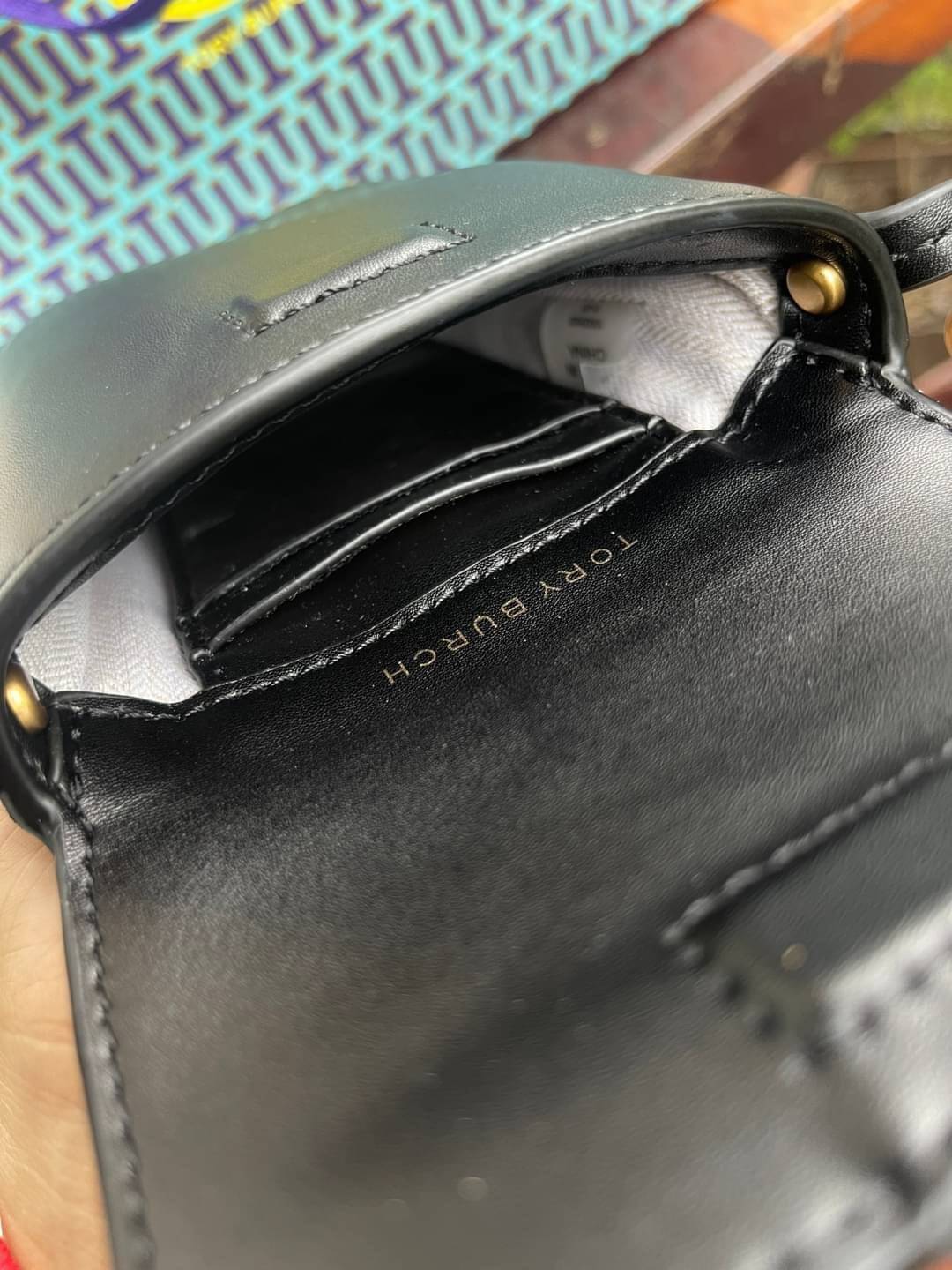 TORY BURCH MILLER METAL PHONE CROSSBODY อีกหนึ่งกระเป๋าใส่มือถือรุ่นฮิตที่เชื่อว่าหลาย ๆ คนต้องเคยเห็นผ่าน ๆ ตามาอย่างแน่นอน กับแบรนด์ Tory Burch ดีไซน์กระเป๋าทรงฝาพับแม่เหล็กใช้งานง่าย มาพร้อมดีเทล Logo แบรนด์โดดเด่นสีทองตัดกับหนังแกะสีดำ ดูหรูดูแพง! แต่