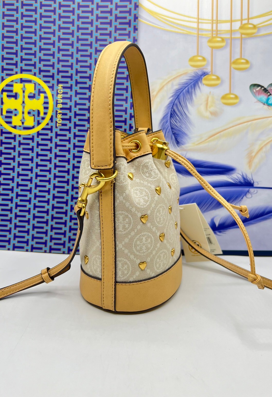 TORY BURCH T MONOGRAM EMBELLISHED MINI BUCKET BAG NEW IVORY MULTI กระเป๋าทรงบัคเก็ตแต่งหัวใจสีทองสวยหรู น่ารักรุ่นใหม่ล่าสุด เกรดท็อปออริ เทียบแท้ 1:1 เกรดดีสุด ใช้งานต่างประเทศได้