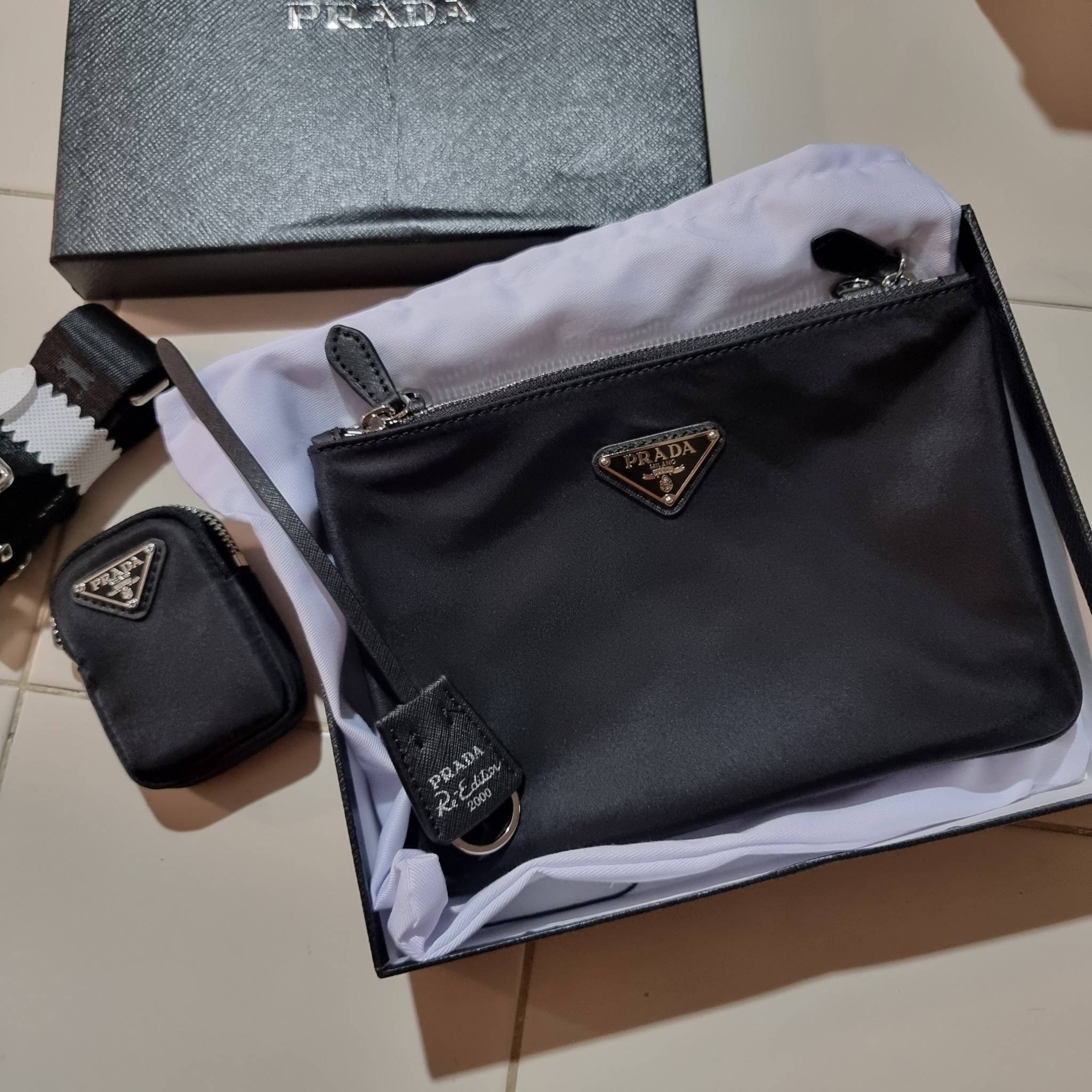 PRADA RE-EDITION 2000 RE-NYLON SHOULDER BAG ไอเท็มสุดโปรด unisex กระเป๋าสะพายข้าง ดีไซน์เรียบง่าย แต่มีความหรูในตัว รูปทรงพกพาสะดวก หยิบใช้ได้ในทุกๆวัน อีกหนึ่งคอลเลคชั่นขายดี วัสดุผ้าไนล่อนคุณภาพ พร้อมใบลูก ไว้ใส่เหรียญ ใส่กุญแจได้สารพัด เปิด-ปิดด้วยซิปห