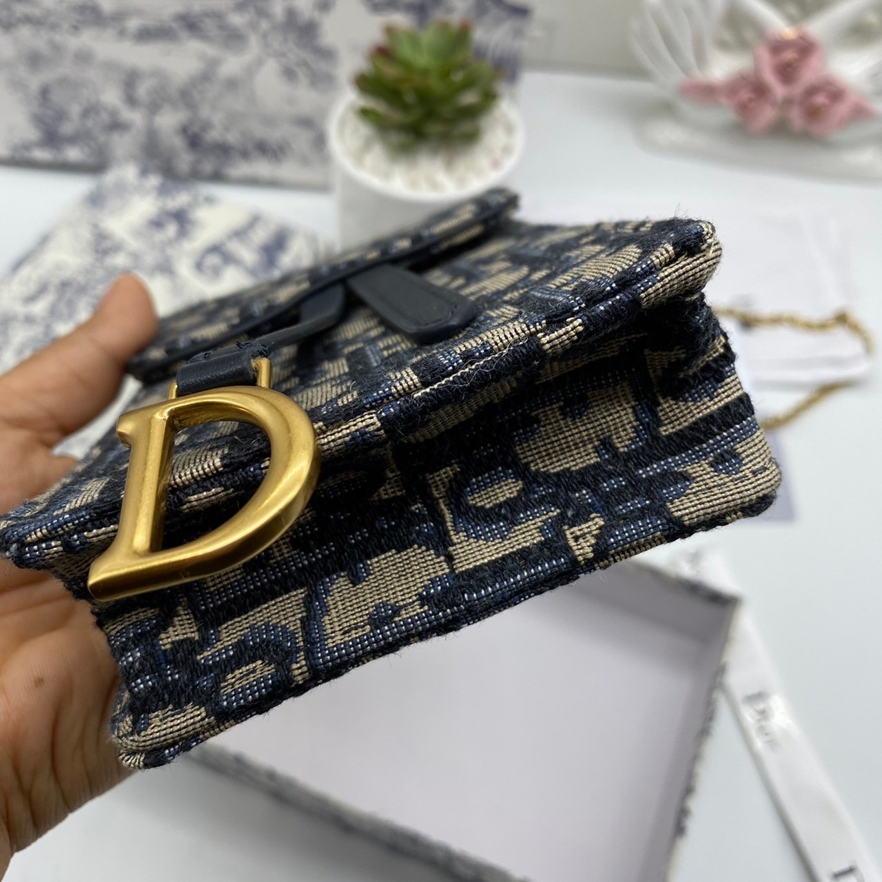 หนังแท้ DIOR PHONE BAG / DIOR PHONE HOLDER BAG กระเป๋าใส่โทรศัพท์เอกลักษณ์ของความหรู สายสะพายโซ่อะไหล่ทอง วัสดุหนังแท้และผ้า Jacquard อย่างดีสวยงามที่สุด ผสมผสานความสง่างามและคลาสสิกที่เข้ากับยุคสมัย ด้านหน้าโดดเด่นด้วยซิกเนเจอร์แบรนด์ เป็นอีกหนึ่งรุ่นที่