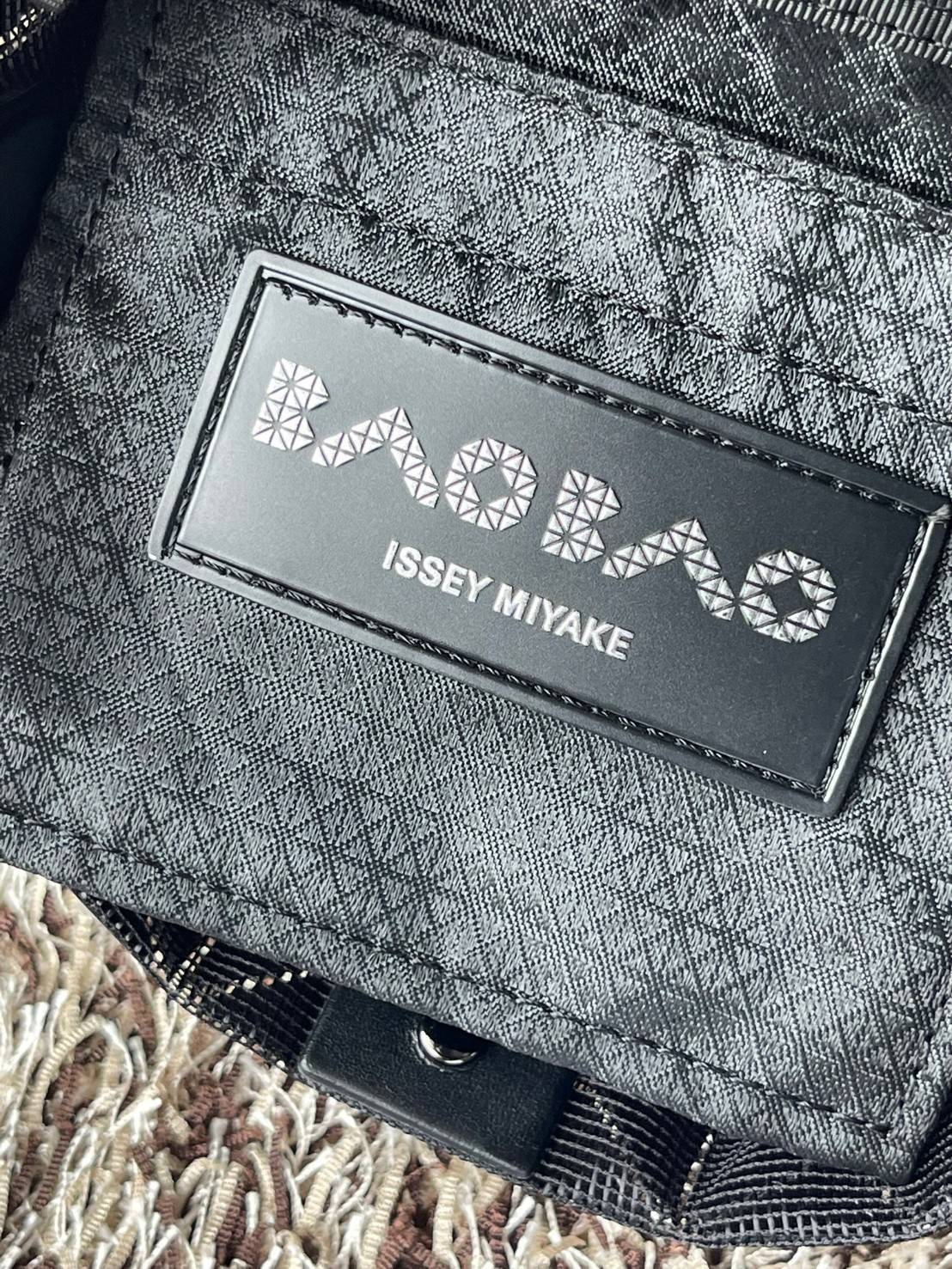 Small : BAO BAO ISSEY MIYAKE SMALL BUCKET เป็นกระเป๋าบัคเก็ตขนาดเล็กสามารถใช้ใส่กระเป๋าสตางค์และโทรศัพท์มือถือได้ ซีรีย์ใหม่นี้มีจุดเด่นที่แผ่นรูปทรงสี่เหลี่ยมด้านขนานในแนวตั้ง เกิดเป็นรูปทรงสามมิติซึ่งแตกต่างไปจากรูปทรงที่เกิดขึ้นจากแผ่นสามเหลี่ยม หูหิ้ว