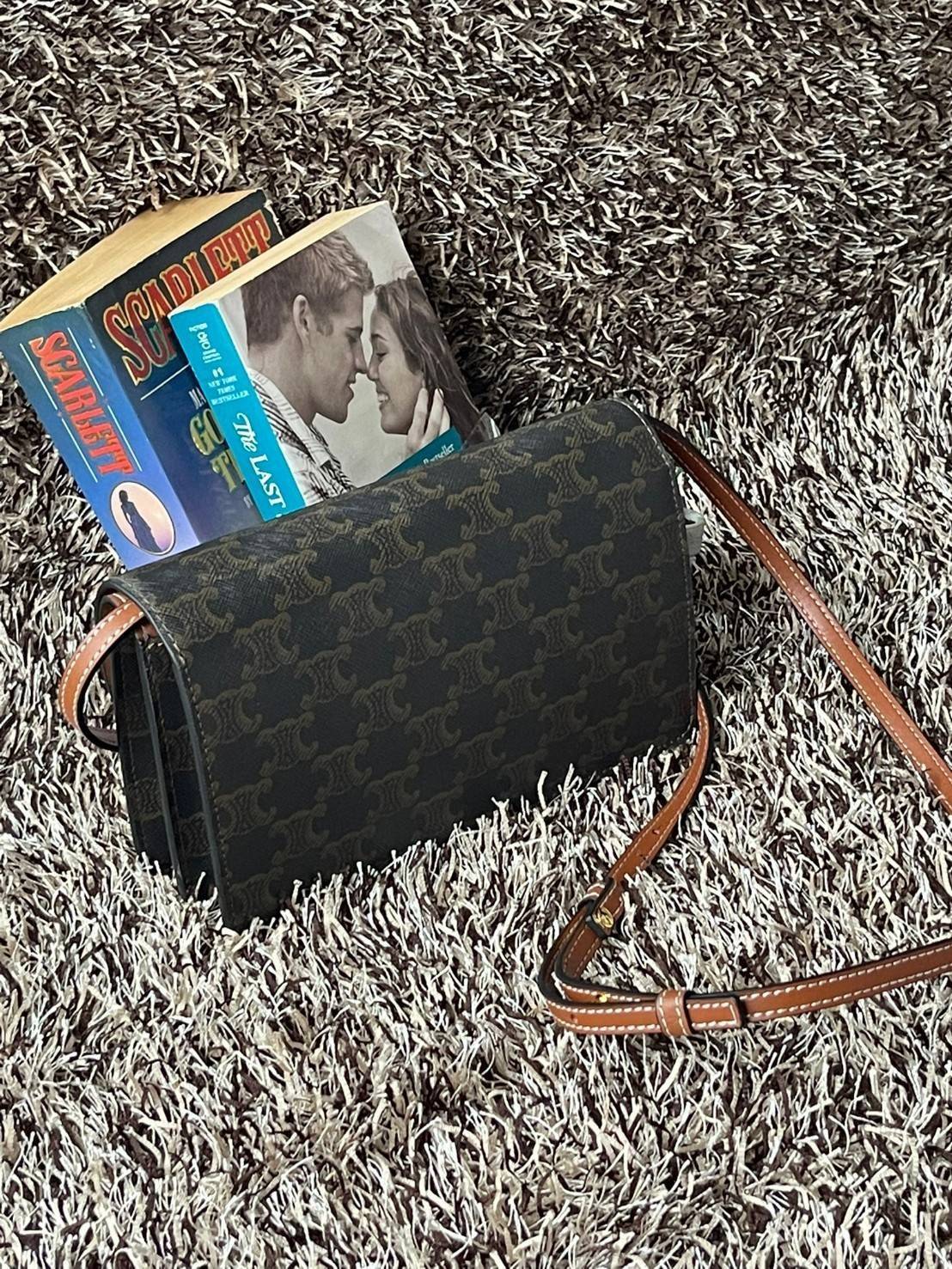 CELINE WALLET ON STRAP IN TRIOMPHE CANVAS กระเป๋าสะพายไหล่สุดเก๋ใบนี้ผลิตจากผ้าใบเคลือบอย่างดีพร้อมขอบหนังสีน้ำตาล กระเป๋ามีสายสะพายหนังสีน้ำตาลพร้อมฮาร์ดแวร์สีทอง ถอดสายออกเพื่อเป็นกระเป๋าถือทรงคลัชท์เปลี่ยนลุคช์ ลวดลายtriomphe ความเป็นแบรนด์ CELINE ได้อ