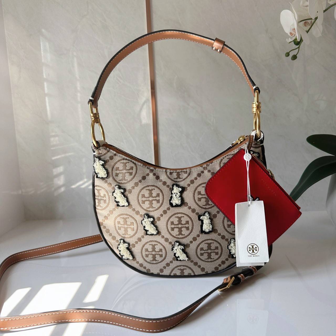 TORY BURCH Mini T Monogram Embroidered Rabbit Crescent Bag 🐇 คอลเลคชั่นกระต่ายสุดร้อนแรงแห่งปี 🥕🥕 คอลเลคชั่นทีบ่งบอกสไตล์ที่ทันสมัยทรงครึ่งวงปักลายกระต่ายบนกระเป๋าสุดน่ารัก โด่ดเด่น