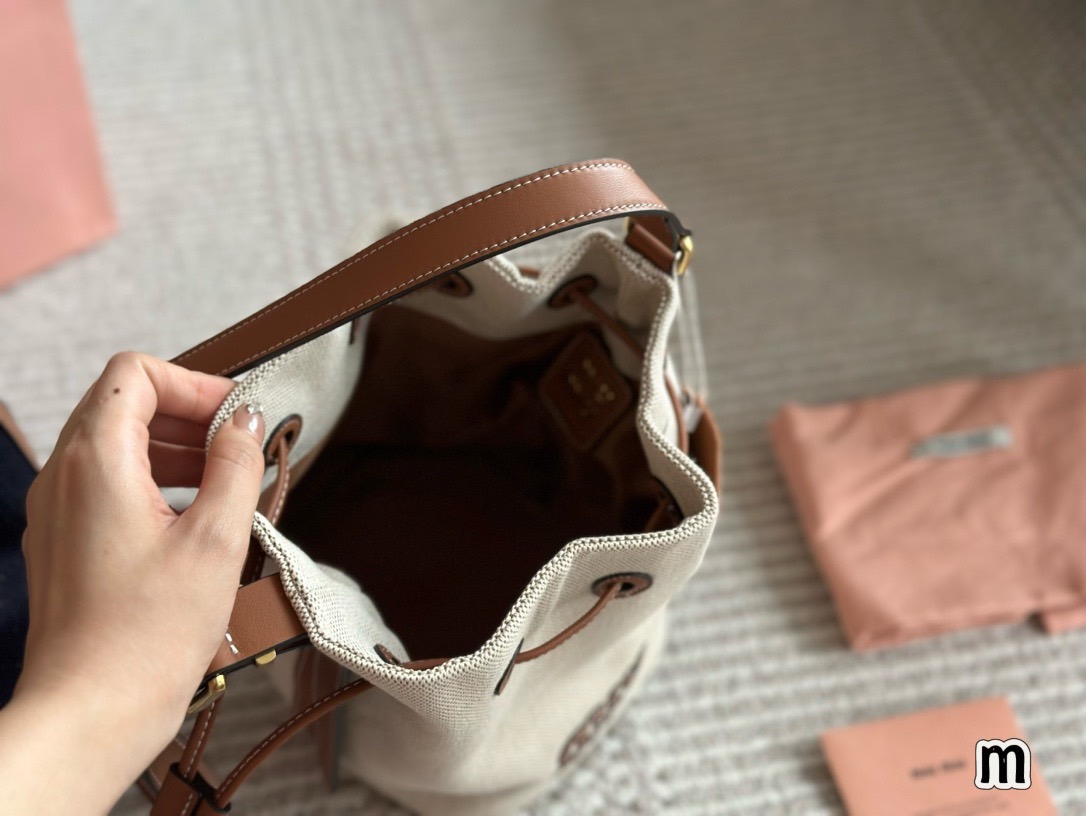 MIU MIU Canvas and leather bucket bag / MIU MIU Bucket Bag กระเป๋าทรงบัคเก็ต ผ้าแคนวาสอย่างดีตกแต่งโลโก้เพิ่มสัมผัสอันเป็นเอกลักษณ์