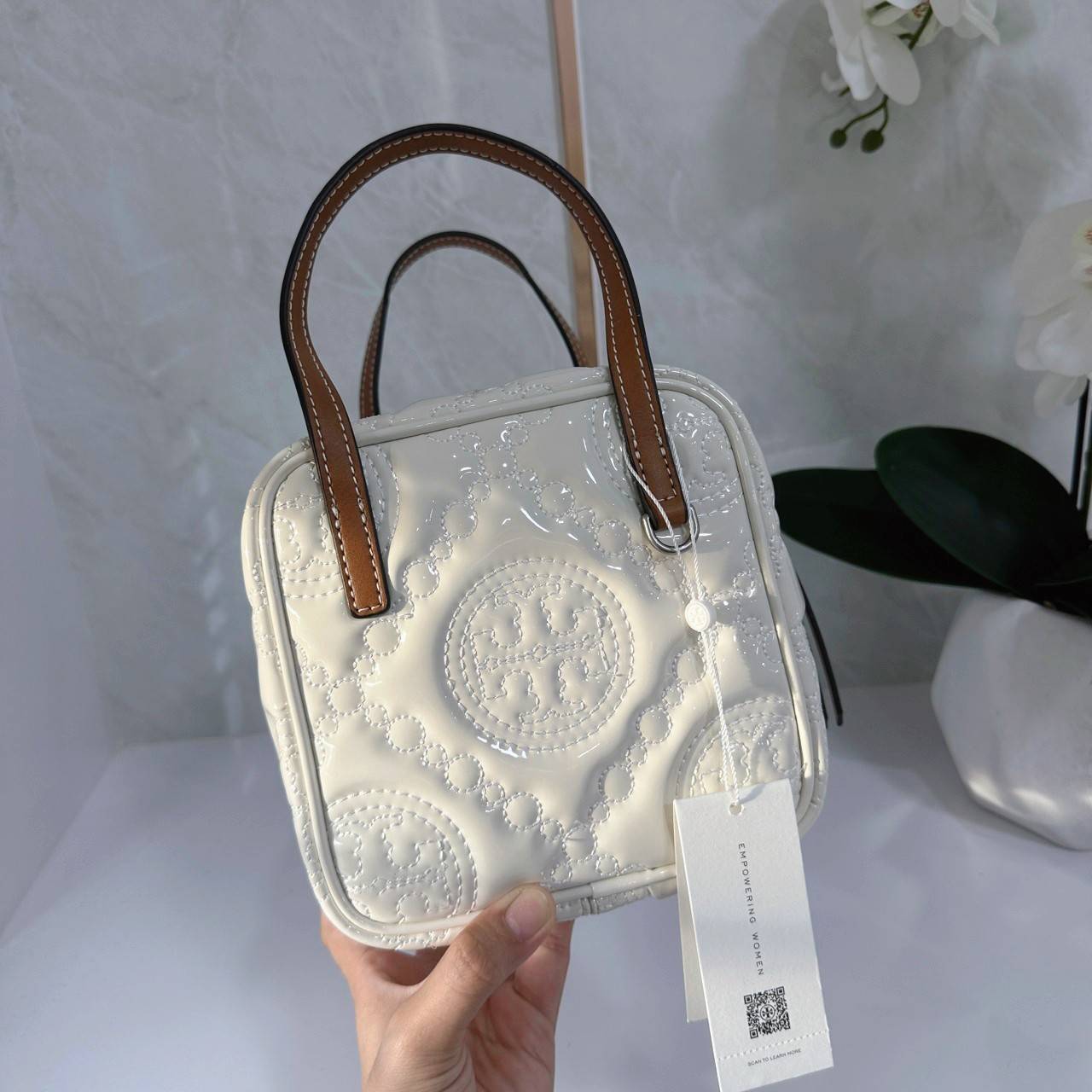 Tory Burch T Monogram Embroidered Patent Cube คอลเลคชั่นใหม่ รุ่นลิมิเต็ดรูปทรงใหม่ T Monogram สุดcube วัสดุหนังแท้ เปิด-ปิดด้วยซิป ภายในกว้าง มีช่องแยก 1 ช่อง สามารถใส่โทรศัพท์มือถือได้ทุกรุ่น สามารถถือหิ้วหรือสะพายได้ สายสามารถถอดและปรับระดับได้คะ