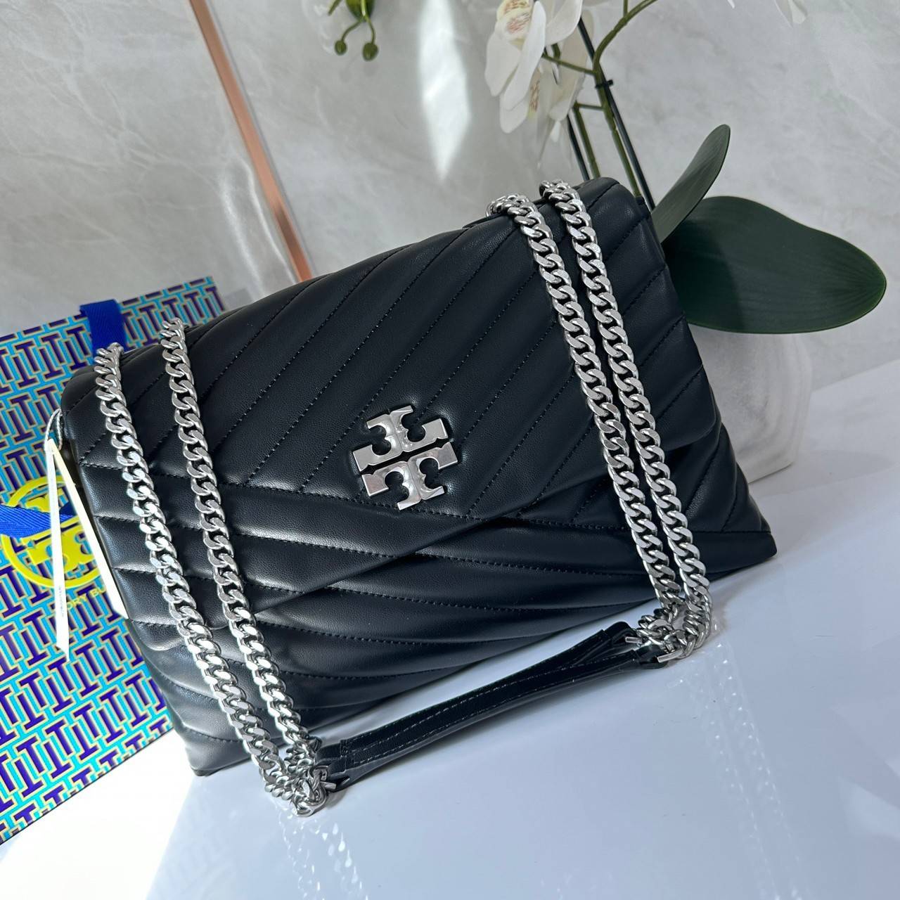 TORY BURCH KIRA CHEVRON CONVERTIBLE SHOULDER BAG กระเป๋าสะพายไซส์ใหญ่ หรูหราสุดคลาสสิก วัสดุหนังแกะทั้งใบ เปิด-ปิดด้วยกระดุมแม่เหล็ก ภายในเป็นช่องโล่ง ใส่ของสำคัญได้ครบ สายสะพายในตัวปรับได้ 2 แบบ สะพายไหล่โซ่คู่หรือจะ ครอสบอดี้ก็เริ่ดคะ
