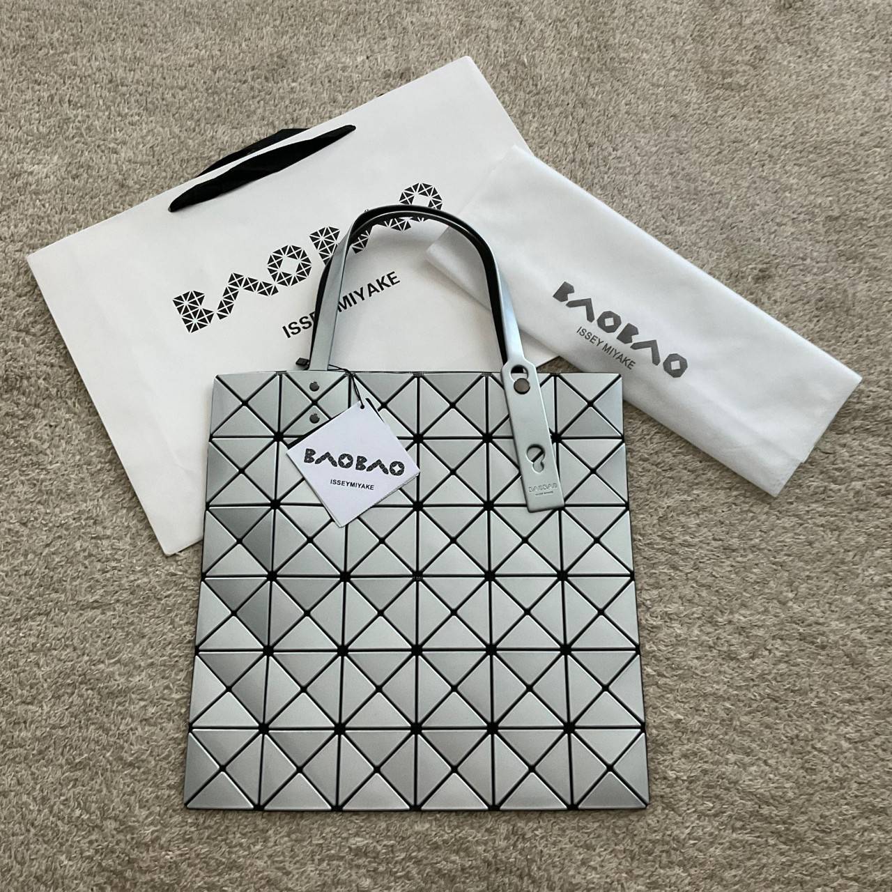 BAO BAO ISSEY MIYAKE TOTE BAG (6x6) กระเป๋าสะพายไหล่ ใบใหญ่ ทรงโท้ท จุดเด่นคือ ปรับได้หลายทรงตามเอกลักษณ์เฉพาะของแบรนด์นี้ ด้านในใส่ของได้เยอะมาก ใส่ไอแพด สมุดโน้ตได้สบายเลย พร้อมช่องซิปใส่ของให้อีกหนึ่งช่อง วัยทำงานหรือวัยนักศึกษา อย่างน้อยต้องมีแบรนด์นี