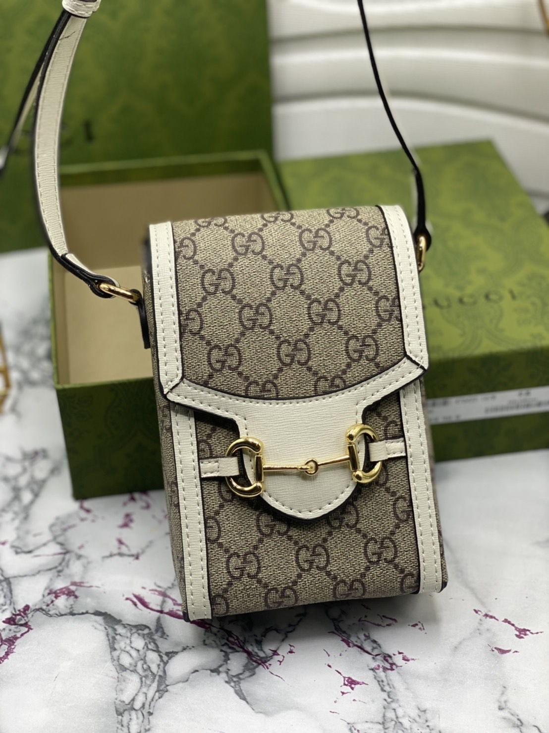 หนังแท้ GUCCI Horsebit phone bag กระเป๋าสะพาย กระเป๋าใส่โทรศัพท์สุดคลาสสิก หนังวัวแท้สีน้ำตาล/สีขาว อะไหล่ทองสวย ดีไซต์สัญลักษณ์วงแหวนตามแบบฉบับแบรนด์ สายสะพายยาวที่สามารถปรับระดับได้ ภาพสินค้าถ่ายจากงานขายจริง ใช้งานต่างประเทศได้ค่ะ