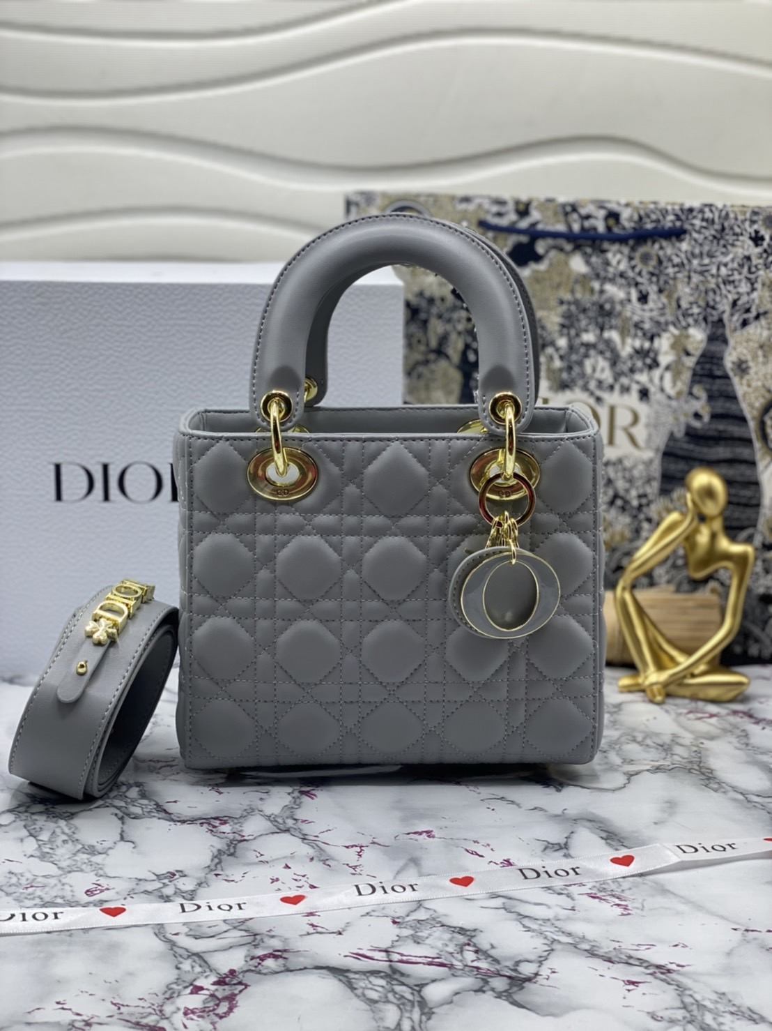 หนังแท้ DIOR LADY BAG 20cm ความสง่างามอีกหนึ่งรุ่นของ Dior รูปทรงสีเหลียม ขนาดกระทัดรัด ตั้งอยู่ทรง ฐานกระเป๋าแข็งแรง มีหมุดรองฐาน ดีไซน์ที่มีเอกลักษณ์เฉพาะตัว ด้านหน้าตกแต่งด้วยตัวอักษร D.I.R ห้อยเป็นพวงกุญแจ จะถือด้วยมือหรือสะพายไหล่ก็ดูดีมากๆ ค่ะ