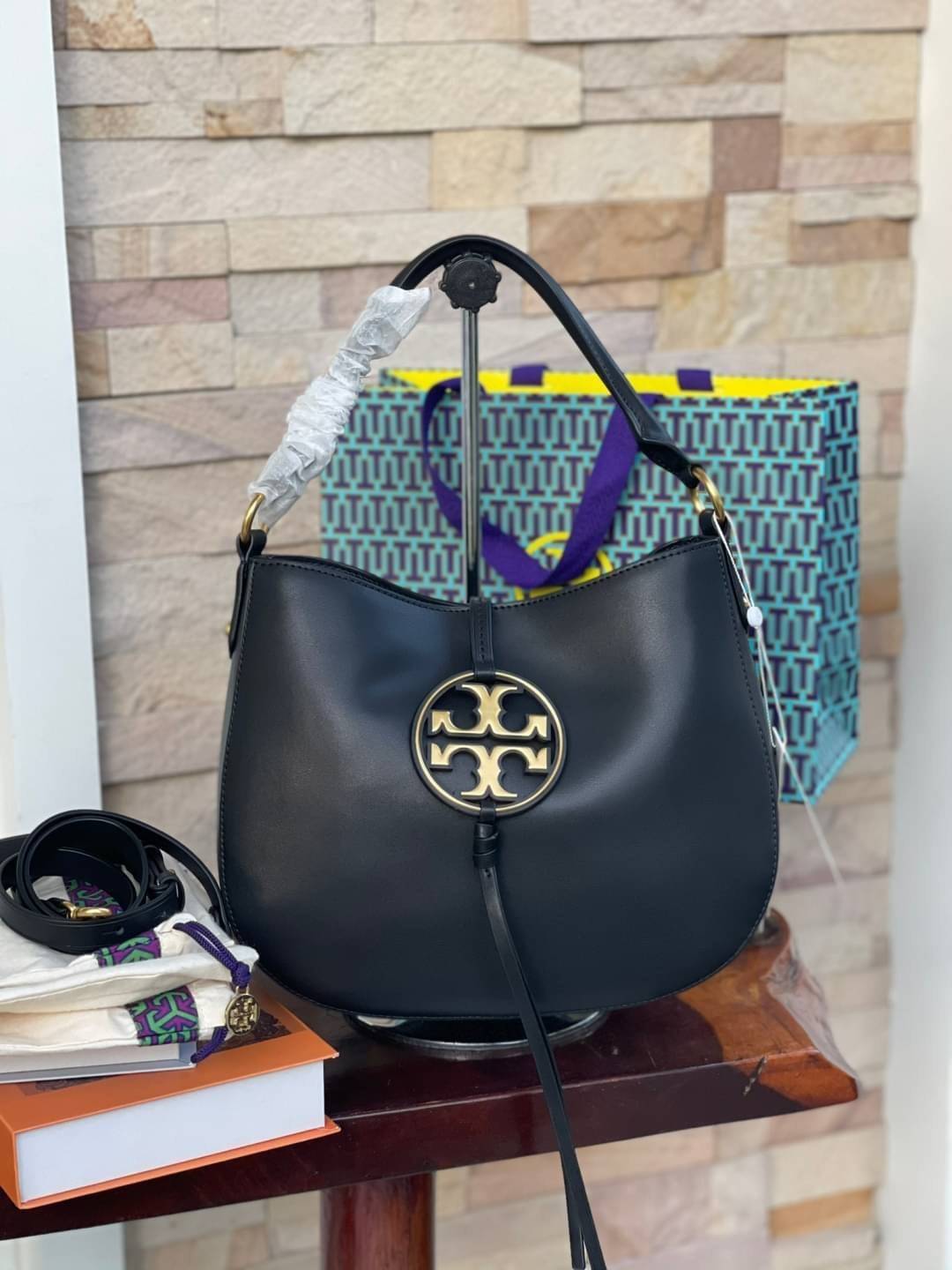 Tory burch miller metal-logo mini hobo bag มีกลิ่นอายสุดคลาสสิก ได้รับแรงบันดาลใจมาจากการขี่ม้า จึงได้ดีไซน์กระเป๋าออกมาในรูปแบบอานหลังม้าสุดเก๋ที่สามารถนำไปมิกซ์แอนด์แมทช์กับสไตล์การแต่งตัวได้หลายชนิด ไม่ว่าจะเป็นกับเดรสทรงยาวหรือกางเกงยีนแสนเท่ตัวโปรดขอ