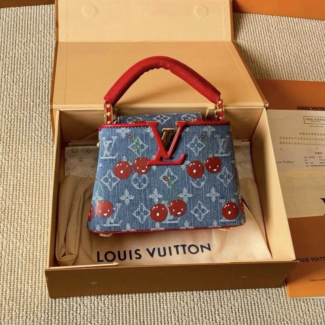 LV Capucines Monogram cherry denim กระเป๋าถือสุดหรูรูปทรงสวยคลาสสิกมาพร้อมหูจับในตัว สวยคมสะกดทุกสายตา ที่สุดของความสวยในราคาเบาๆ โดดเด่นมีชีวิตชีวา ด้วยเดนิมวินเทจปักลายเชอร์รี่สีสันสดใสสะดุดตาสะท้อนสไตล์ไอคอนิก