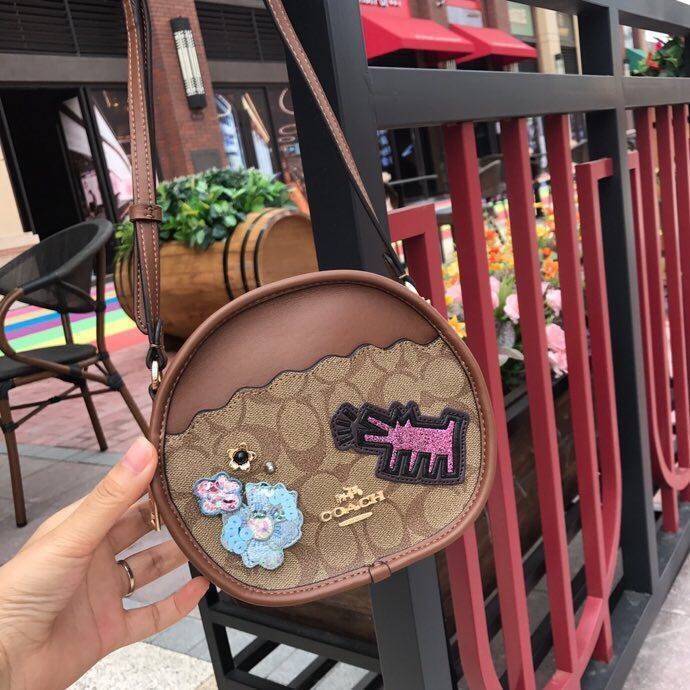 COACH KEITH HARING CANTEEN CROSSBODY IN SIGNATURE CANVAS WITH PATCHES F48730 กระเป๋าทรงกลมสุดเก๋ ไม่เหมือนใคร ตกแต่งลายให้มรความน่ารัก โดดเด่นขึ้นมา สะพายไปไหนก็สวยไม่เหมือนใคร ภายในกว้าง ใส่ของได้เยอะ กระเป๋าเปิดปิดด้วยซิป ใครย้งไม่มี รีบจับ รีบจองกันเลย