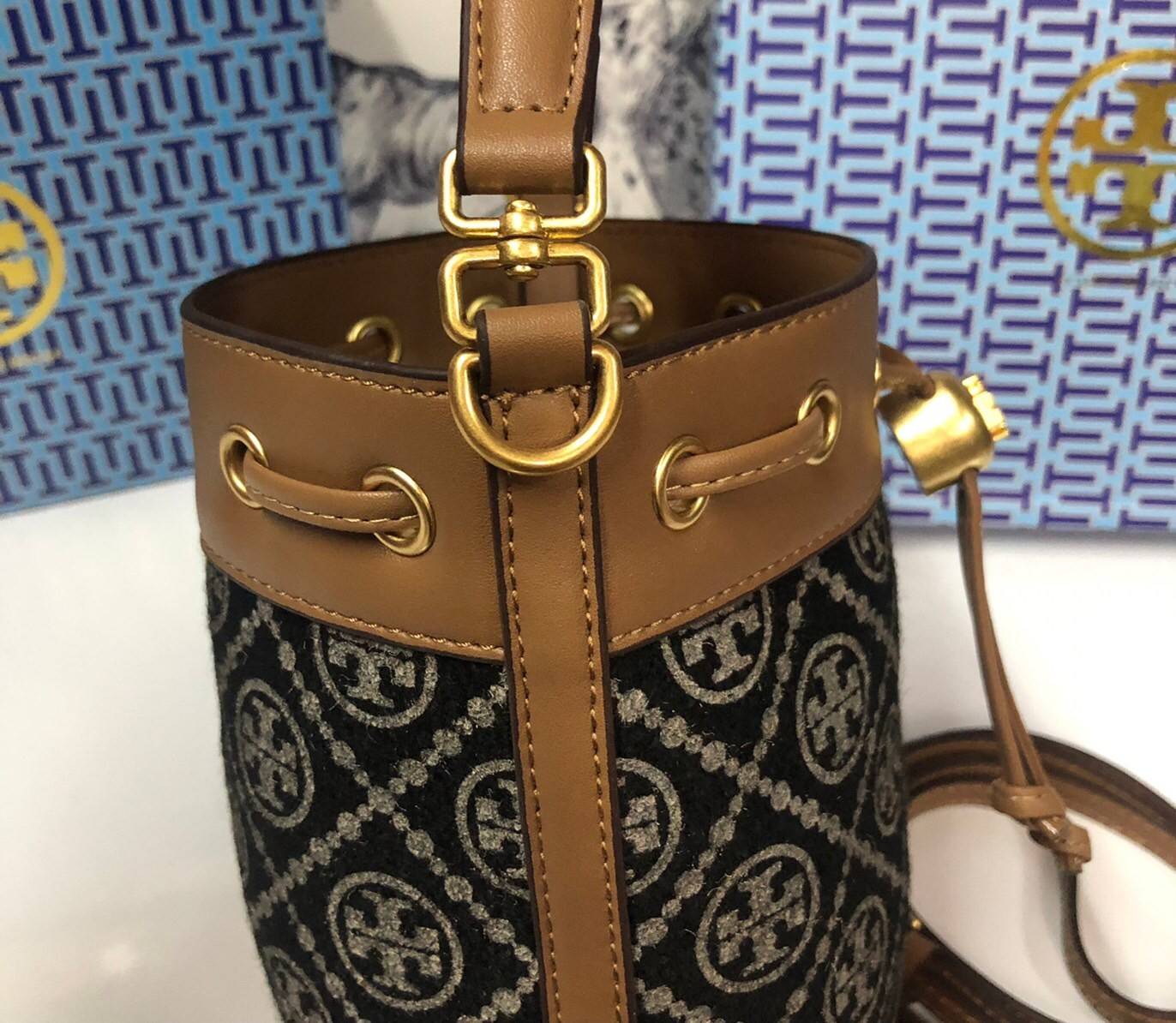 Mini : Tory Burch T Monogram Chenille Bucket Bag เปิดตัวอีกหนึ่งรุ่นกับกระเป๋าลาย T MONOGRAM รุ่นใหม่ล่าสุดจาก TORY BURCH พลาดไม่ได้กับโลโก้สุดคลาสสิก ลวดลาย T Monogram คือวัสดุ chenille หรือที่เรียกว่า ด้านไหมกำมะหยี่ มารังสรรค์ลงบนกระเป๋าBucketใบนี้ เป็