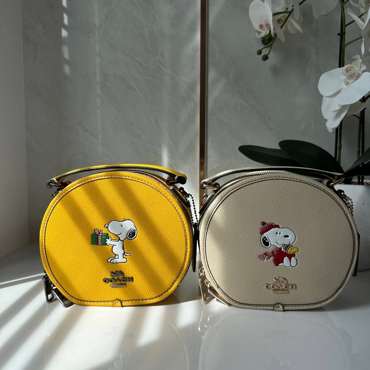 COACH X PEANUTS CANTEEN CROSSBODY WITH SNOOPY PRESENT MOTIF (CE845,CF290) กระเป๋าสะพายข้างทรงกลมไซส์มินิ มีหูจับ วัสหนังแท้ ด้านหน้าโดดเด่นด้วยรูปการ์ตูนSnoopy