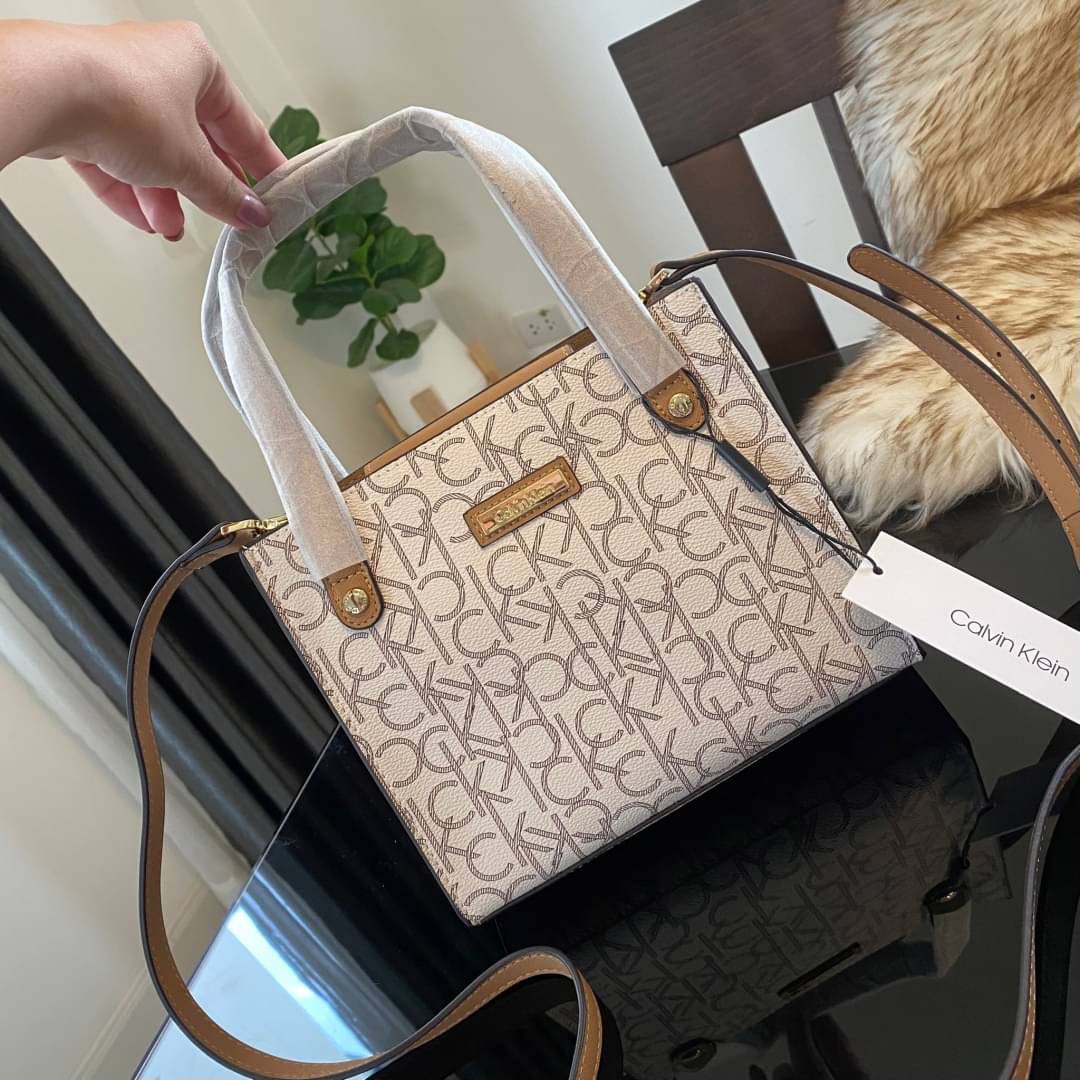 CALVIN KLEIN JEANS crossbody bag กระเป๋าถือหรือสะพาย ลายซิกเนเจอร์แบรนด์ทั้งใบ มีหูจับสำหรับถือ เปิด-ปิดกระเป๋าด้วยกระดุมแม่เหล็ก ด้านในโล่งกว้างมีช่องเล็กและช่องซิปสำหรับใส่ของจุกจิก ซับในลายแบรนด์อย่างดี มาพร้อมสายสะพายยาวปรับระดับได้ สามารถใช้ได้หลากหล