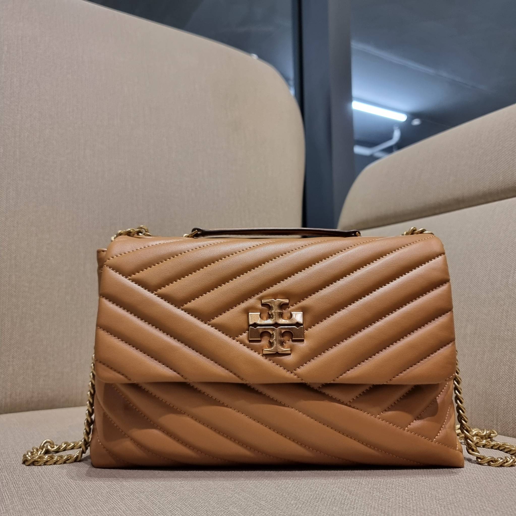 TORY BURCH KIRA CHEVRON CONVERTIBLE SHOULDER BAG กระเป๋าสะพายรุ่นยอดฮิต ไซส์ใหญ่จัดเต็มให้เน้นๆ ใช้ยังไงก็ดูหรู ดีไซน์เฉพาะตัว วัสดุหนังแกะ สัมผัสนิ่ม เปิด-ปิดด้วยกระดุมแม่เหล็ก ภายในเป็นช่องโล่ง แบ่งสัดส่วนไว้ดีมากๆ ใส่กระเป๋าสตางค์ มือถือ เครื่องสำอางค์