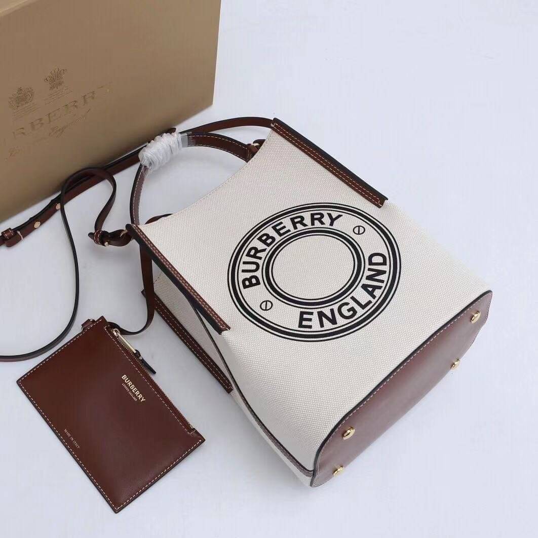 หนังแท้ BURBERRY FRAGRANCES CROSSBODY BUCKET BAG วัสดุ Canvas & Leather สวยหรูอยู่ทรงมาพร้อมกระเป๋าคลัชใบเล็กสีน้ำตาลเข้าชุด ภายในโล่งกว้างและจุ สามารถใส่กล้อง มือถือ ของใช้ได้เยอะ มือจับหนังแข็งแรงหิ้วถนัดมือพร้อมสายสะพายหนังยาวปรับระดับได้ อะไหล่แบรนด์ส