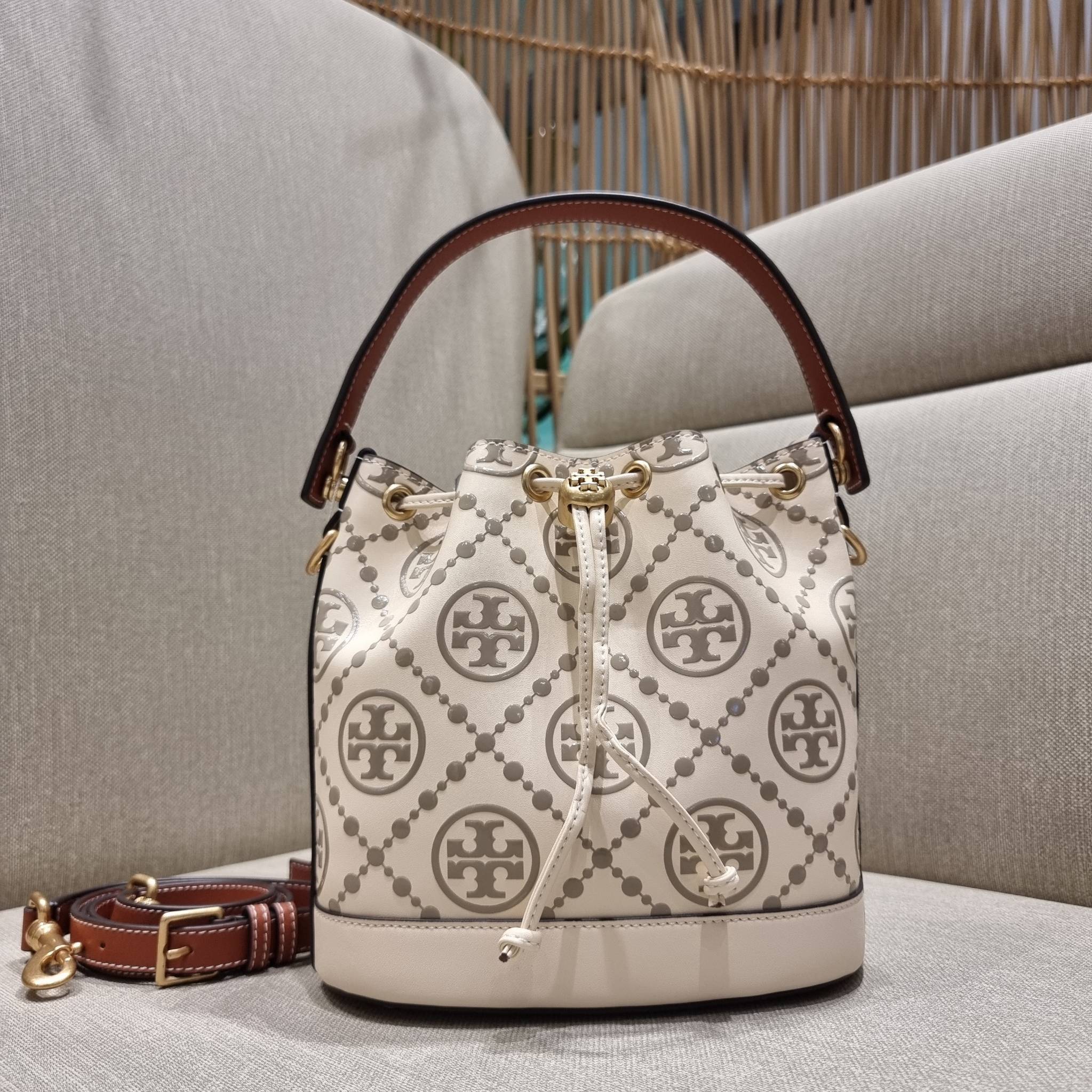 TORY BURCH T MONOGRAM EMBOSSED BUCKET BAG คอลเลคชั่นใหม่ กับกระเป๋าบัคเก็ตทรงยอดนิยม ดีไซน์ใหม่ล่าสุด สวยลูกคุณหนู หรูหรา!! ด้วยดีเทลผิวลายนูนลวดลายเอกลักษณ์ วัสดุหนังแท้ ปากกระเป๋ารูดเปิด-ปิดได้ มีหูจับในตัว สะดวกใช้ไปอีก และมีสายสะพายข้าง ปรับได้อีกด้วย