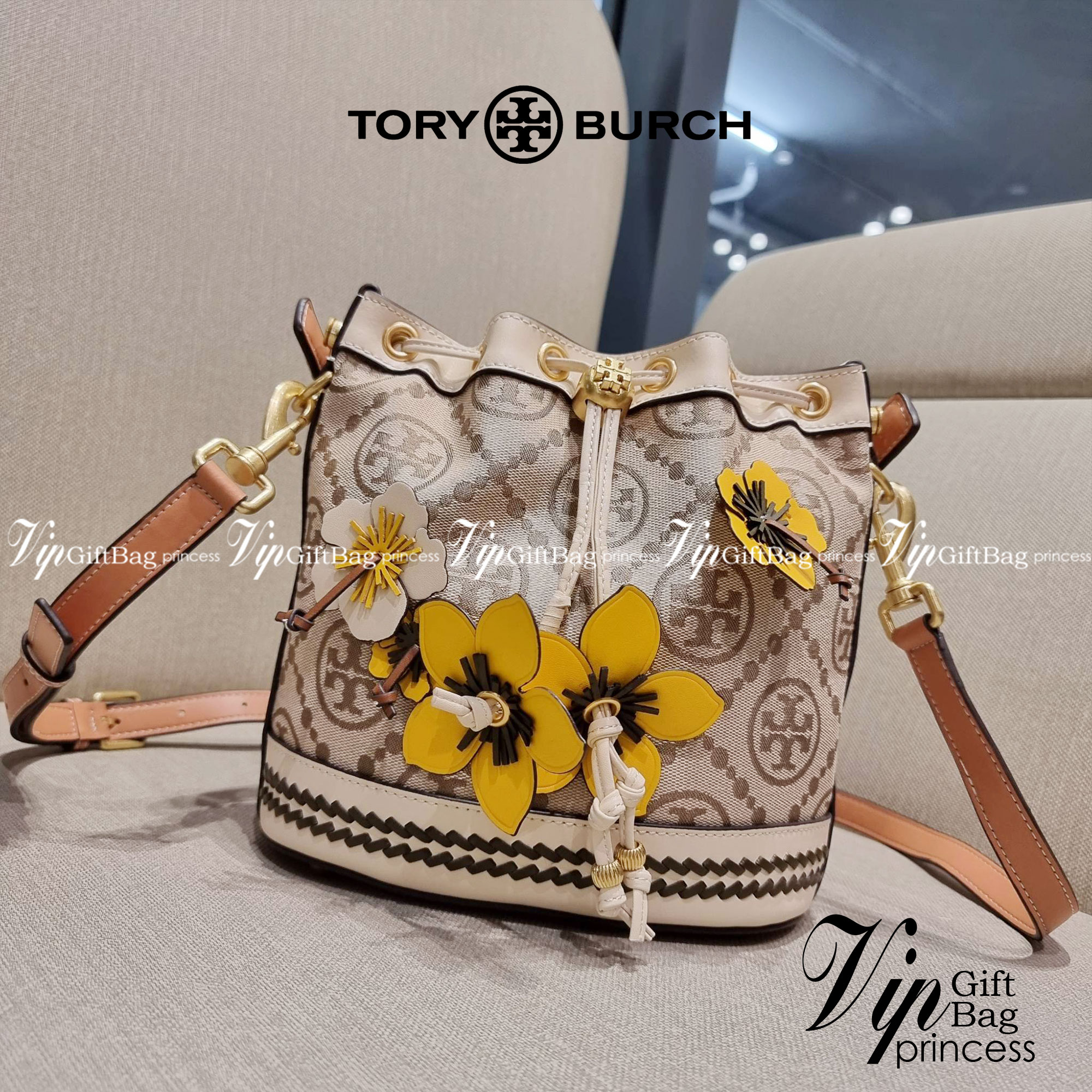 TORY BURCH T MONOGRAM FLORAL BUCKET BAG คอลเลคชั่นใหม่ พร้อมเสิร์ฟความสวยให้ถึงบ้าน!! กระเป๋าบัคเก็ตทรงยอดนิยม ดีไซน์ใหม่ล่าสุด สไตล์งานคราฟ มีลูกเล่นประดับดอกไม้กับตัวกระเป๋า และตัวรูดสาย วัสดุผ้า jacquard ตัดสลับหนังแท้ หูจับและขอบกระเป๋าตกแต่งลายสานสวย