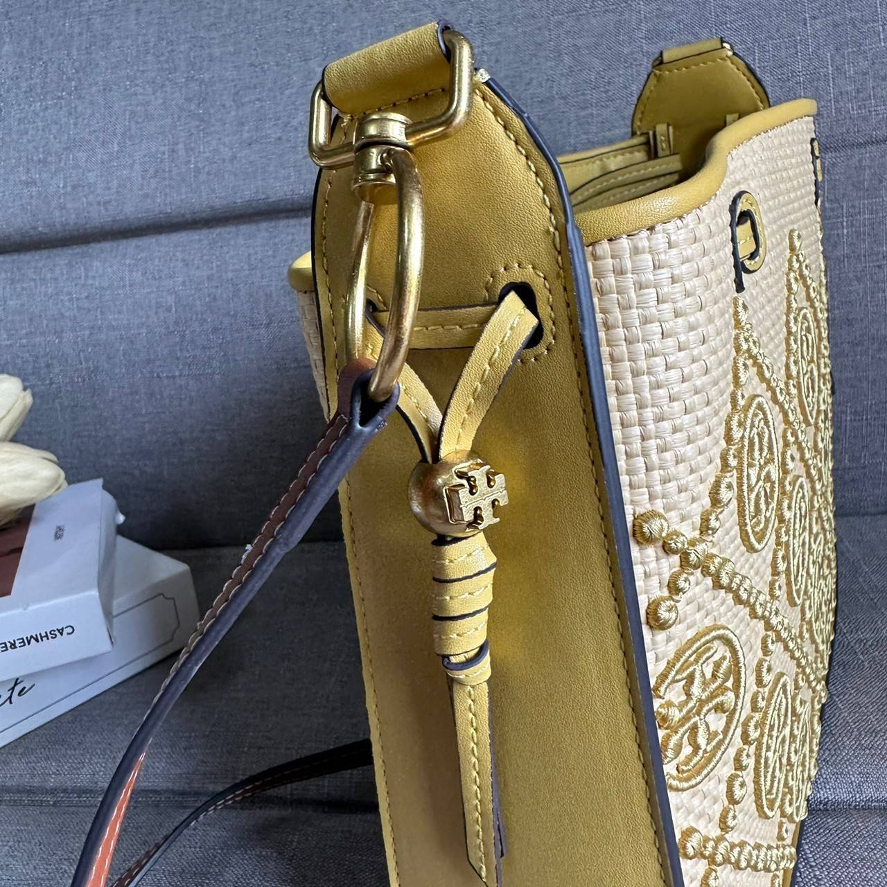 TORY BURCH T Monogram Straw Bell Bag กระเป๋าสะพายข้างรุ่นคลาสสิกที่ได้แรงบันดาลใจจากการควิลท์แบบดั้งเดิมของเพนซิลเวเนีย คอลเลกชันบ่งบอกถึงความมีสไตล์เหนือกาลเวลา รูปทรงเรียวโดดเด่น ปักทอลายแบรนด์อย่างสวยงาม เปิด ปิดด้วยเชือกรูด ด้านในช่องโล่งกว้าง ซับในผ้