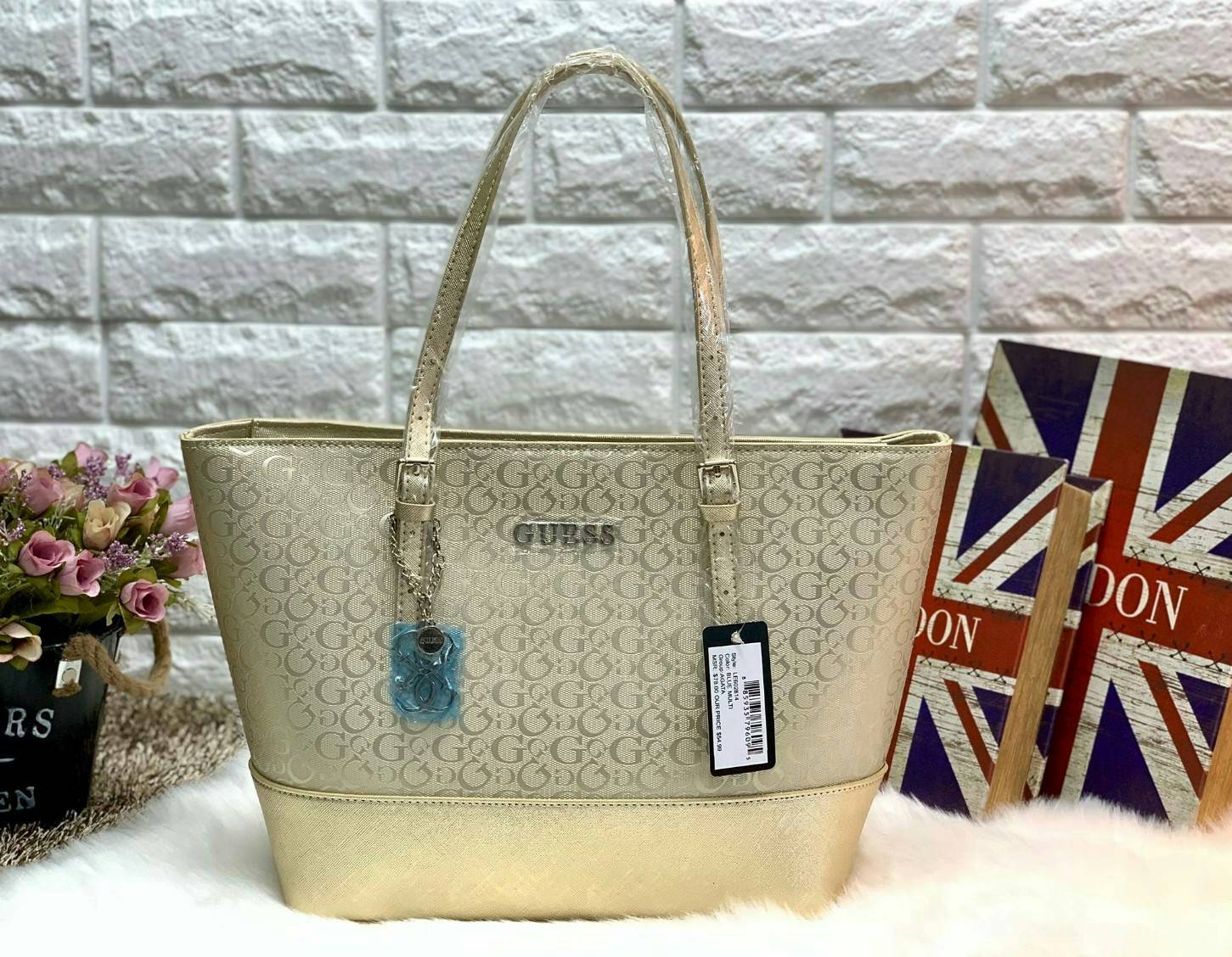 GUESS WOMEN LARGE TOTE BAG กระเป๋าถือ//สะพายไหล่ ทรง Tote ตัวกระเป๋าลายแบรนด์ทั้งใบ ผสมหนังซาฟเฟียโน่ตรงขอบล่างกระเป๋าค่ะ ด้านหน้าห้อยอะไหล่แบรนด์มาให้ เปิดปิดกระเป๋าแบบซิป ภายในโล่ง กว้าง ใส่ของได้จุค่ะ มีช่องซิปและช่องเล็กใส่ของจุกจิกนะค่ะ หูหิ้วสามารถป